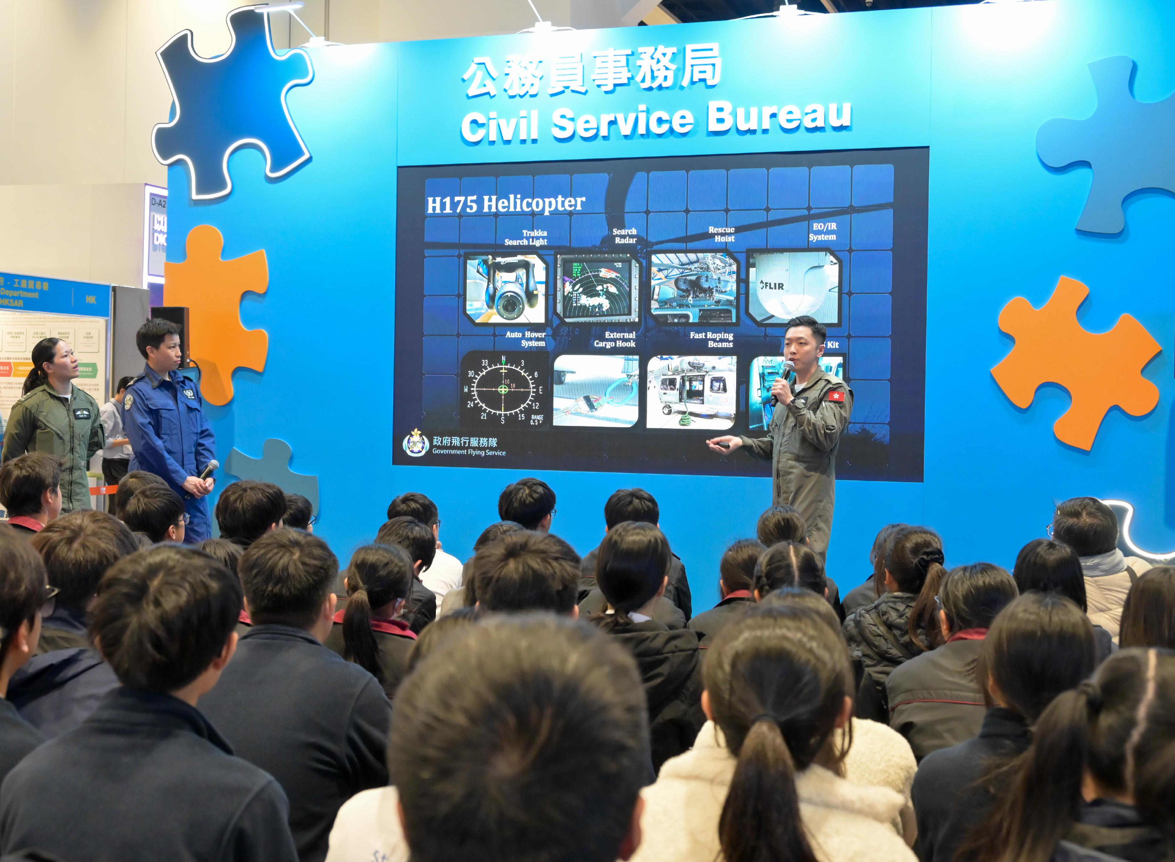 The Civil Service Bureau has newly set up a government stage area this year at the Education & Careers Expo 2026, allowing departments to introduce the unique work experiences and achievements of different grades as well as relevant recruitment information, and to interact with visitors through a series of seminars. Photo shows participants learning more about the work of the Government Flying Service at the government stage area today (January 22).