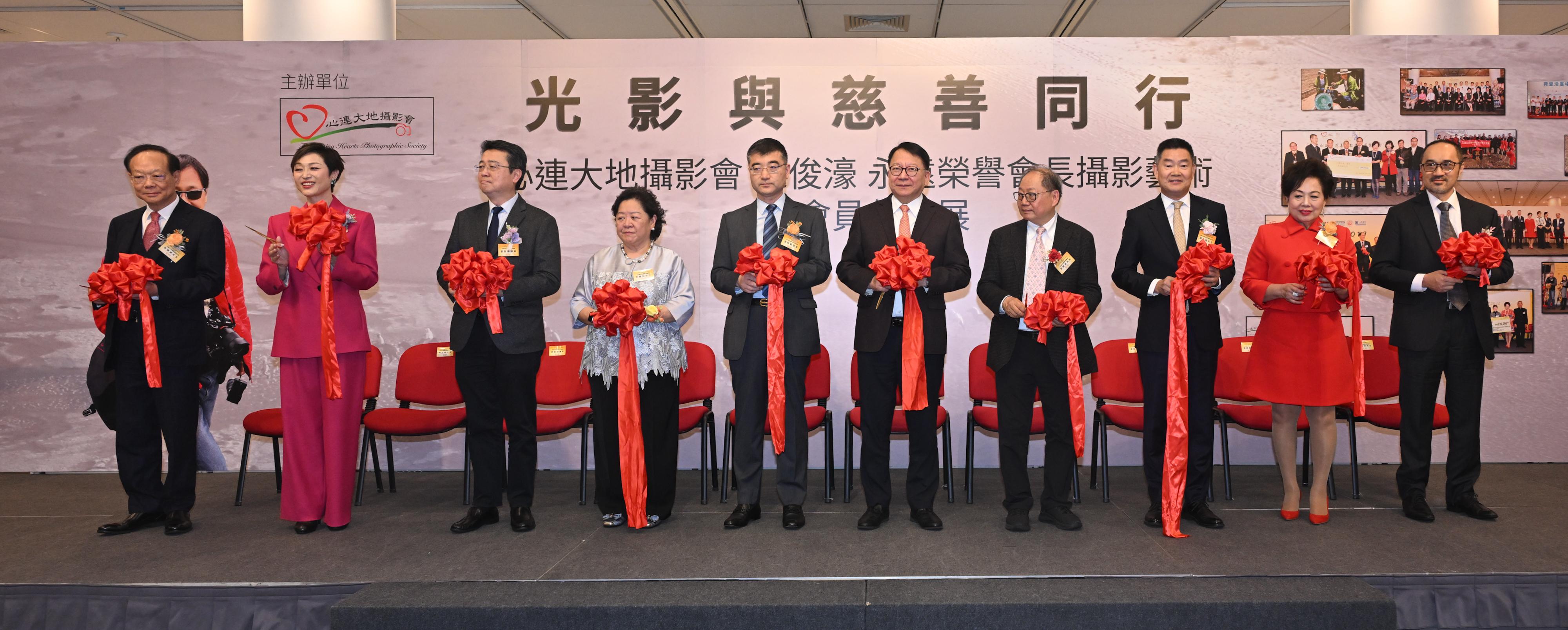 政務司司長陳國基今日（一月三十一日）出席光影與慈善同行　心連大地攝影會陳俊濠永遠榮譽會長攝影藝術暨會員作品展開幕儀式。圖示（左五起）中央人民政府駐香港特別行政區聯絡辦公室社會工作部副部長張昭、陳國基、心連大地攝影會會長鄧贊禹和其他嘉賓在活動合照。