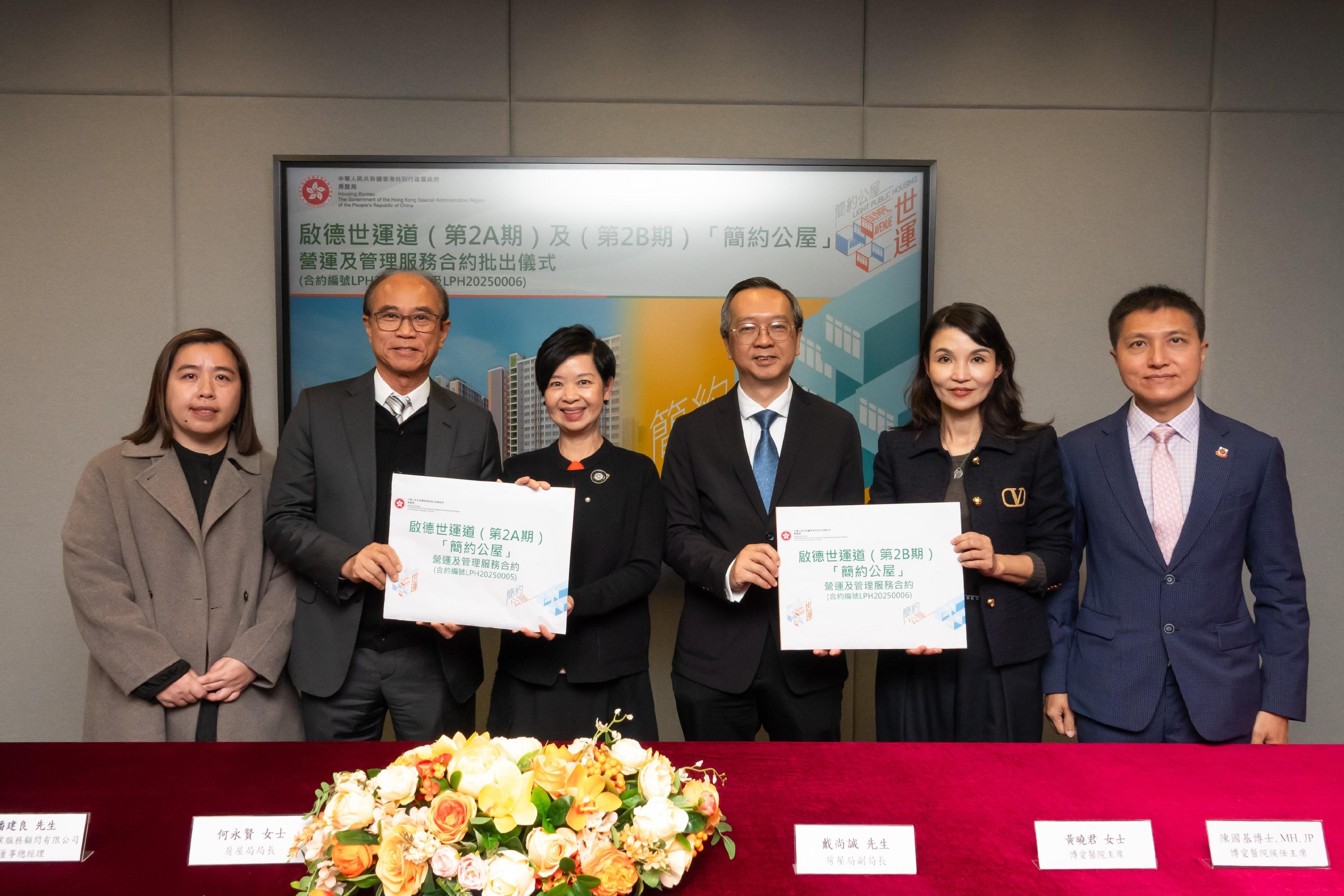 房屋局今日（二月二日）批出兩份「簡約公屋」項目的營運及管理服務合約。圖示房屋局局長何永賢（左三）及房屋局副局長戴尚誠（右三）在批出合約的儀式上，與啟德世運道「簡約公屋」（第2A期）及（第2B期）項目營運及管理服務合約（合約編號LPH20250005和LPH20250006）的中標機構創毅物業服務顧問有限公司&mdash;&mdash;博愛醫院聯營代表合照。