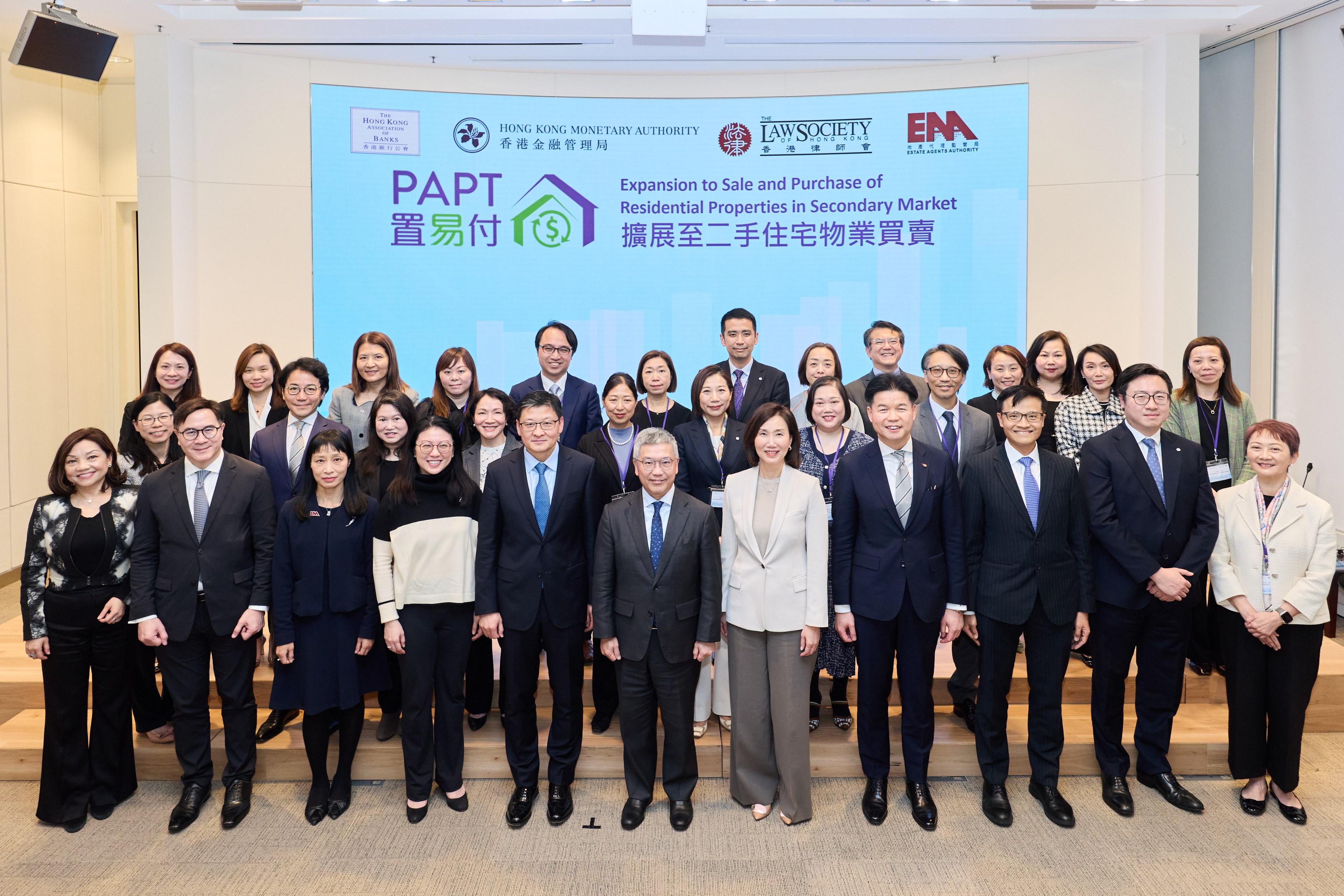 香港金融管理局（金管局）副總裁阮國恒（前排中）、香港銀行公會主席、中國銀行（香港）有限公司副董事長兼總裁孫煜（前排左五）、香港律師會會長湯文龍（前排右四）、地產代理監管局規管及法律總監梁德麗（前排左三）、香港上海滙豐銀行有限公司香港區行政總裁伍楊玉如（前排左四）、渣打香港兼大中華及北亞區行政總裁禤惠儀（前排右五）、消費者委員會副總幹事何應富（前排左二）、金管局助理總裁（銀行操守）區毓麟（前排右三）、香港銀行同業結算有限公司行政總裁鄧月容（前排左一）及參與試點計劃的銀行代表今日（二月五日）出席「置易付」發布會。