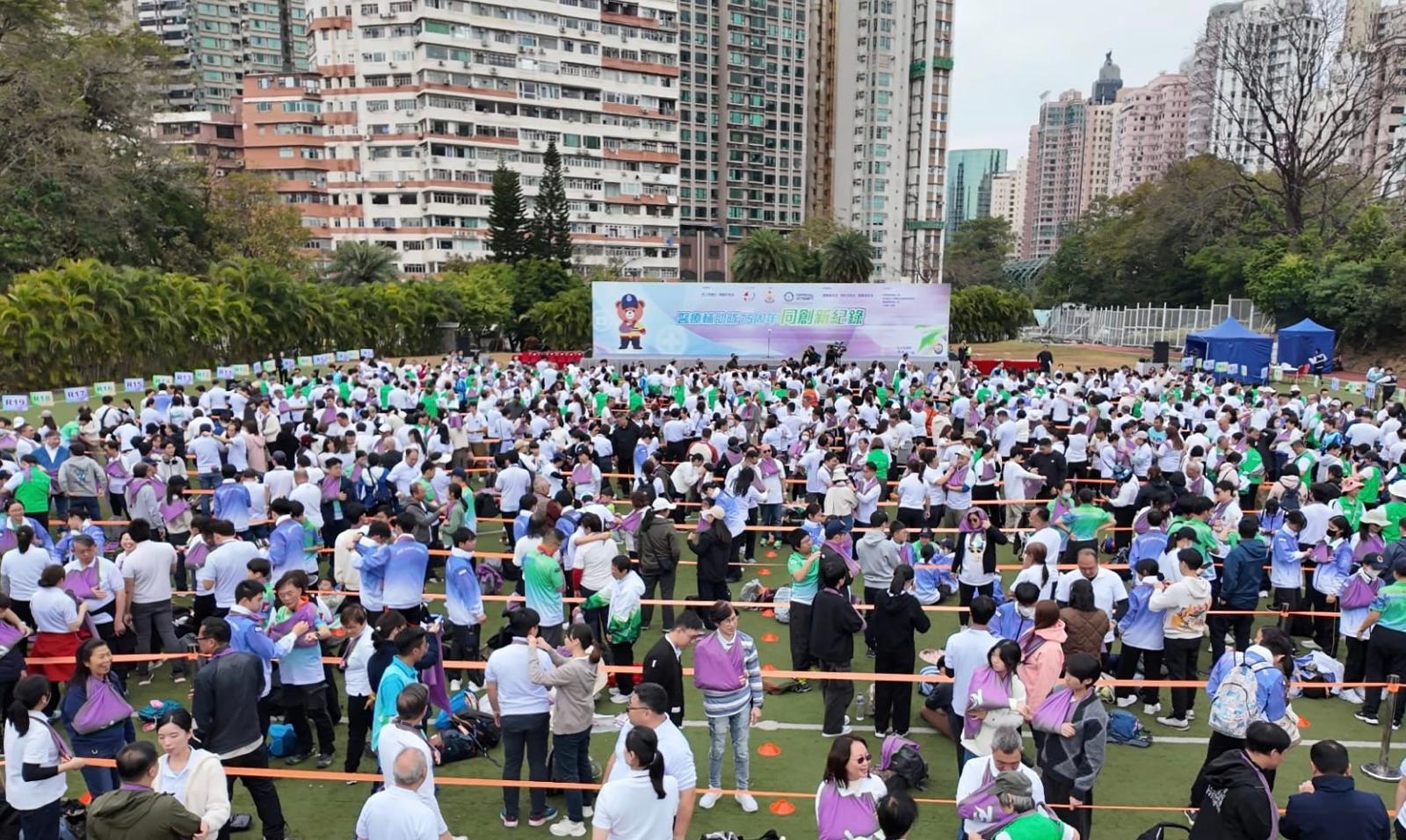 The Auxiliary Medical Service today (February 8) held the "Together, We Set a New Record" event to celebrate its 75th anniversary at Wah Yan College, Kowloon. Photo shows nearly a thousand participants performing "arm slings" using triangular bandages.