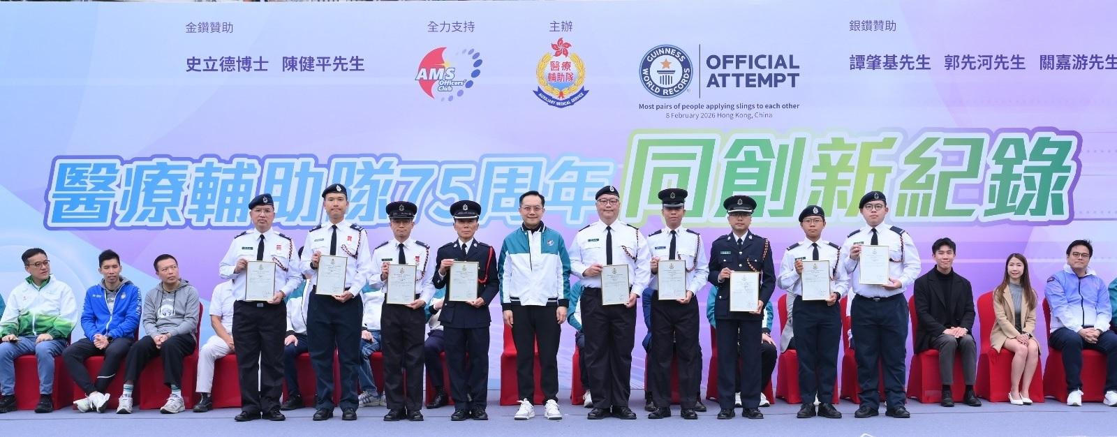 The Auxiliary Medical Service (AMS) today (February 8) held the "Together, We Set a New Record" event to celebrate its 75th anniversary at Wah Yan College, Kowloon. Photo shows members with outstanding performance in providing first-aid and nursing care services in the "Standard Chartered Hong Kong Marathon 2026" being commended by the Commissioner of the AMS, Dr Ronald Lam (front row, fifth left).