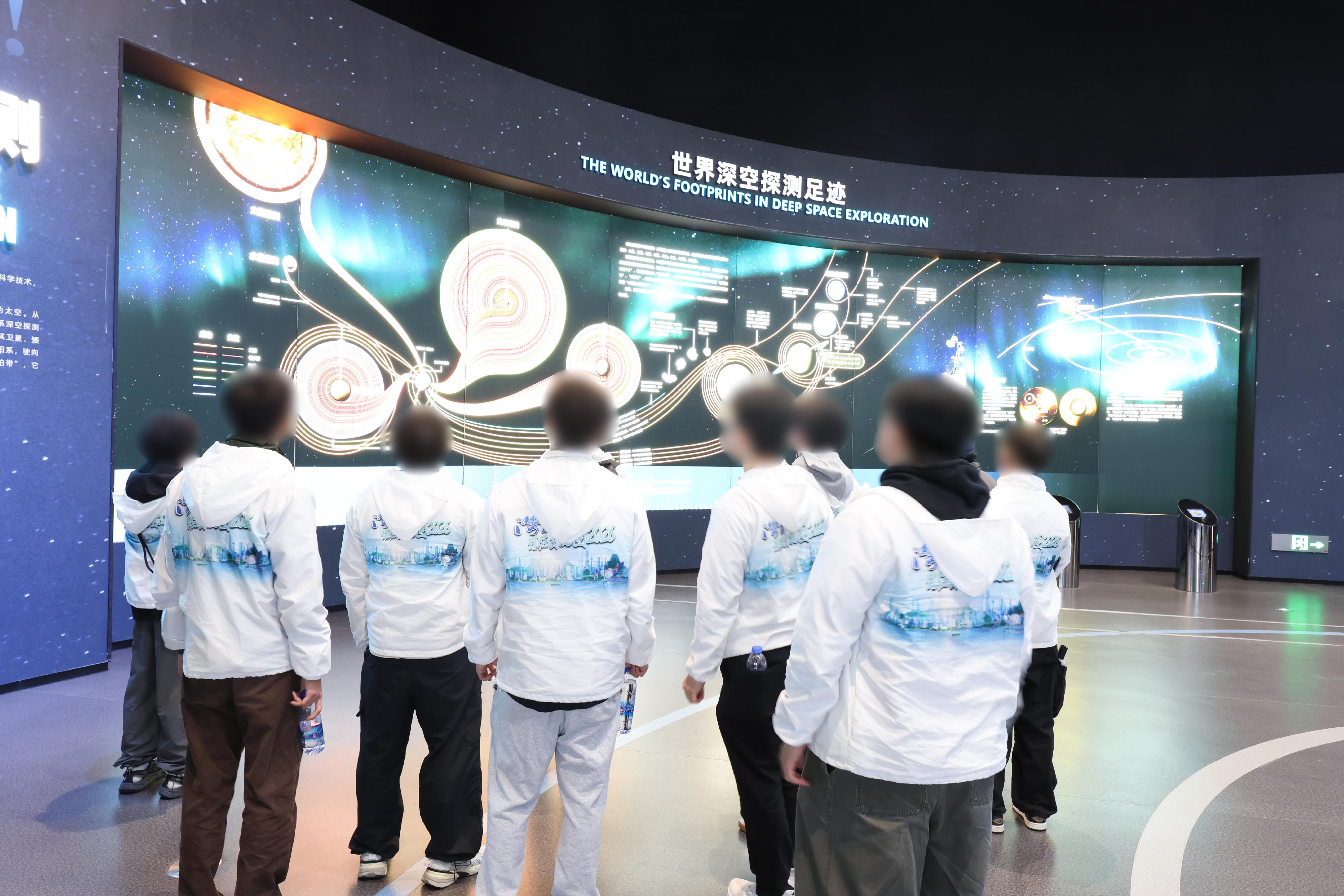 為進一步培養青少年更生人士的國家觀念及正確價值觀，懲教署人員率領已完成服刑並正接受監管的青少年參與「灣區體驗交流團2026」，前往位於粵港澳大灣區的佛山及珠海進行三日兩夜交流，認識國家歷史文化和不同領域的發展。圖示青少年更生人士於二月八日參觀珠海一間太空中心，了解國家的航天科技成果。