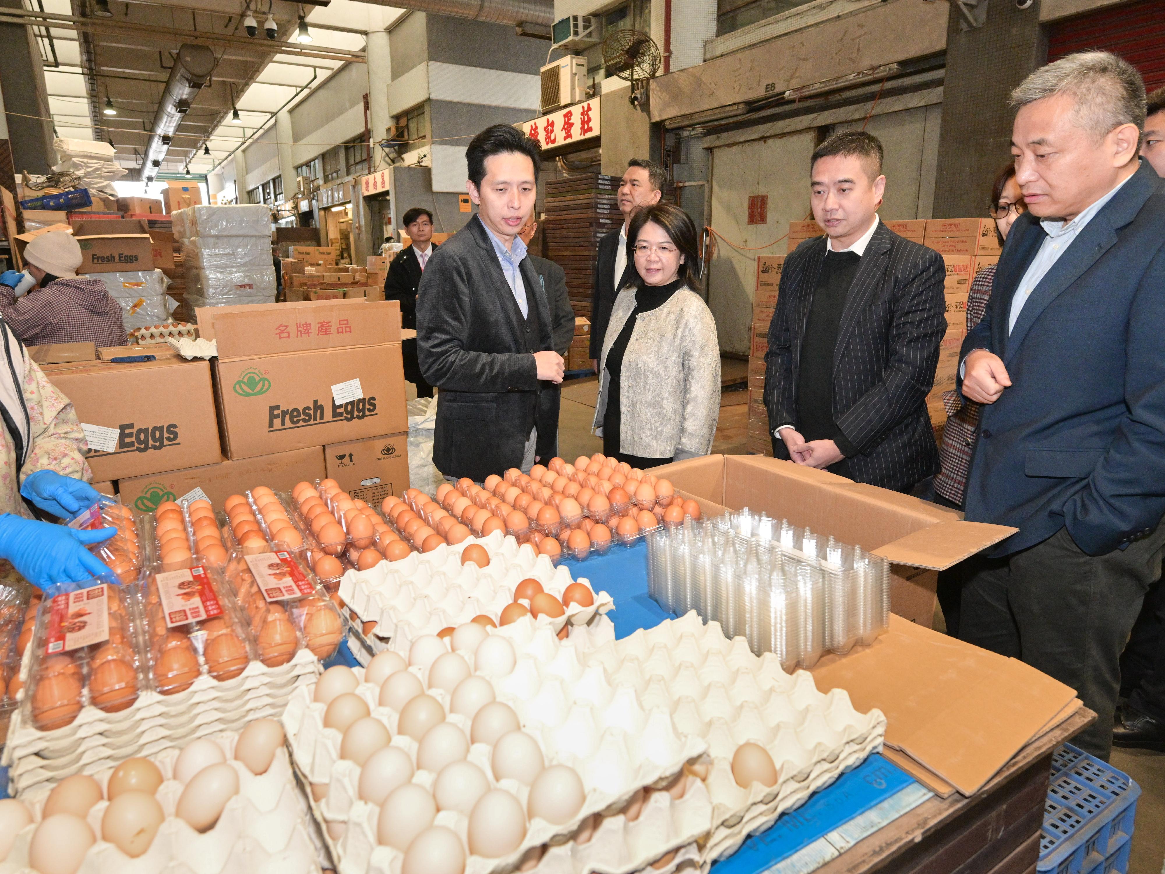The Deputy Director General of the Department of Foreign Trade, Ministry of Commerce of the People's Republic of China, Ms Li Na, today (February 9) led a delegation to Hong Kong to ensure the stable supply of quality and safe agricultural products from the Mainland to Hong Kong during the Chinese New Year. Photo shows Ms Li (second left), the Deputy Director-General of the Economic Affairs Department and Head of the Commercial Office of the Liaison Office of the Central People's Government in the Hong Kong Special Administrative Region, Mr Zhou Qiang (first right), and the delegation visiting the Western Wholesale Food Market to observe the distribution of fresh food.