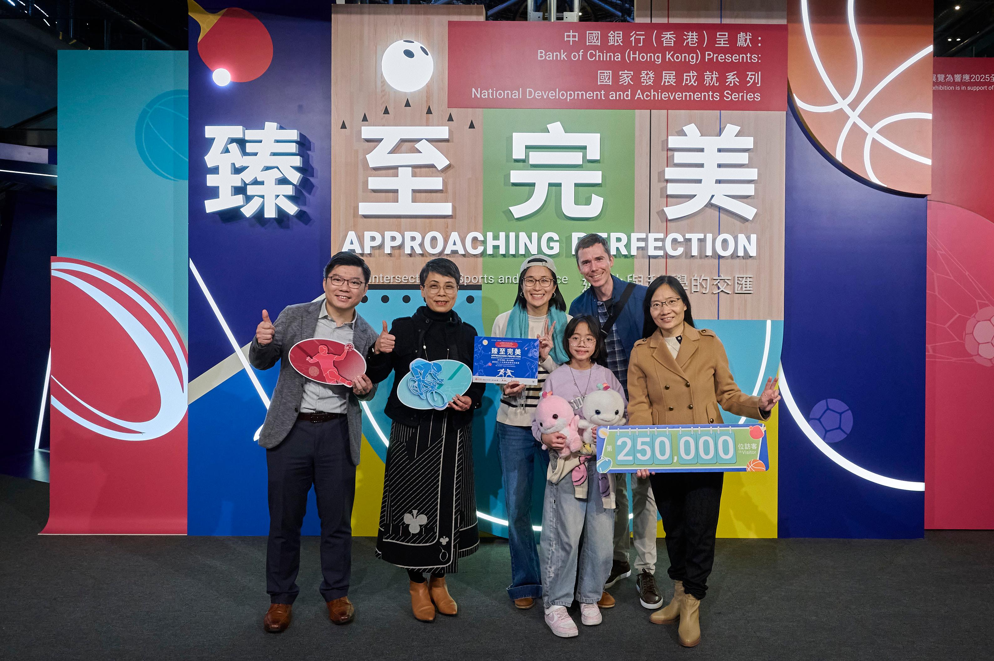 現正在香港科學館舉行的「中國銀行（香港）呈獻：國家發展成就系列──臻至完美：運動與科學的交匯」展覽，昨日（二月十日）迎來第二十五萬名參觀者。圖示康樂及文化事務署副署長（文化）譚美兒（左二）、中國銀行（香港）企業社會責任辦公室副總經理葉麗麗（右一），及香港科學館總館長劉啟業（左一）向參觀者送上紀念品。