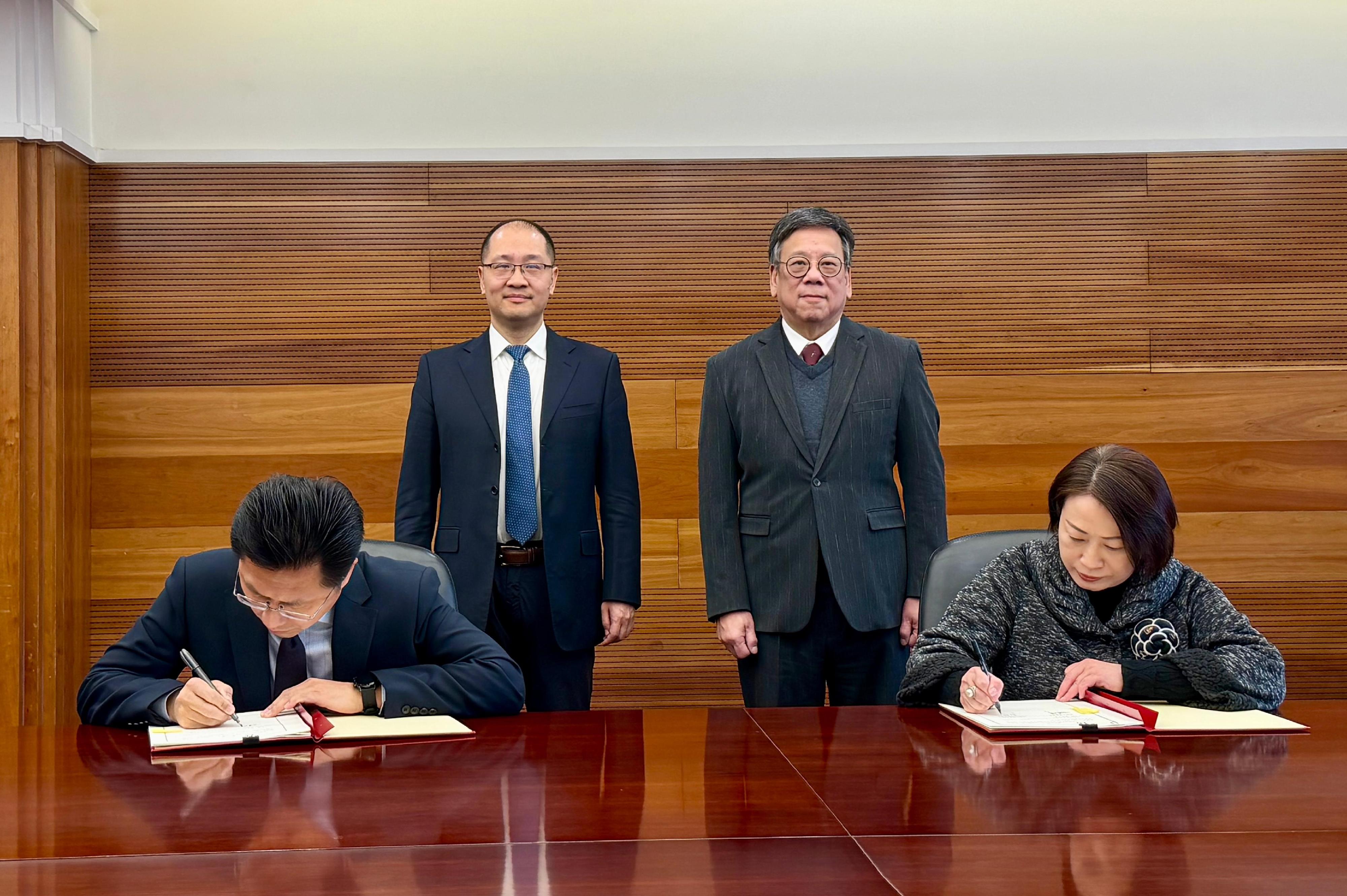 The Commerce and Economic Development Bureau and the Ministry of Commerce (MOC) signed a Memorandum of Understanding (MOU) today (February 11) in Beijing to strengthen co-operation and exchange in the provision of comprehensive overseas services to support Mainland enterprises to go global. Photo shows the Secretary for Commerce and Economic Development, Mr Algernon Yau (back row, right), and Member of the Communist Party of China Leadership Group of the MOC and Assistant Minister Mr Zhang Li (back row, left) witnessing the signing of the MOU by the Acting Permanent Secretary for Commerce and Economic Development, Miss Grace Kwok (front row, right), and the Director General of the Department of Outward Investment and Economic Cooperation of the MOC, Mr Zhao Chunfeng (front row, left).