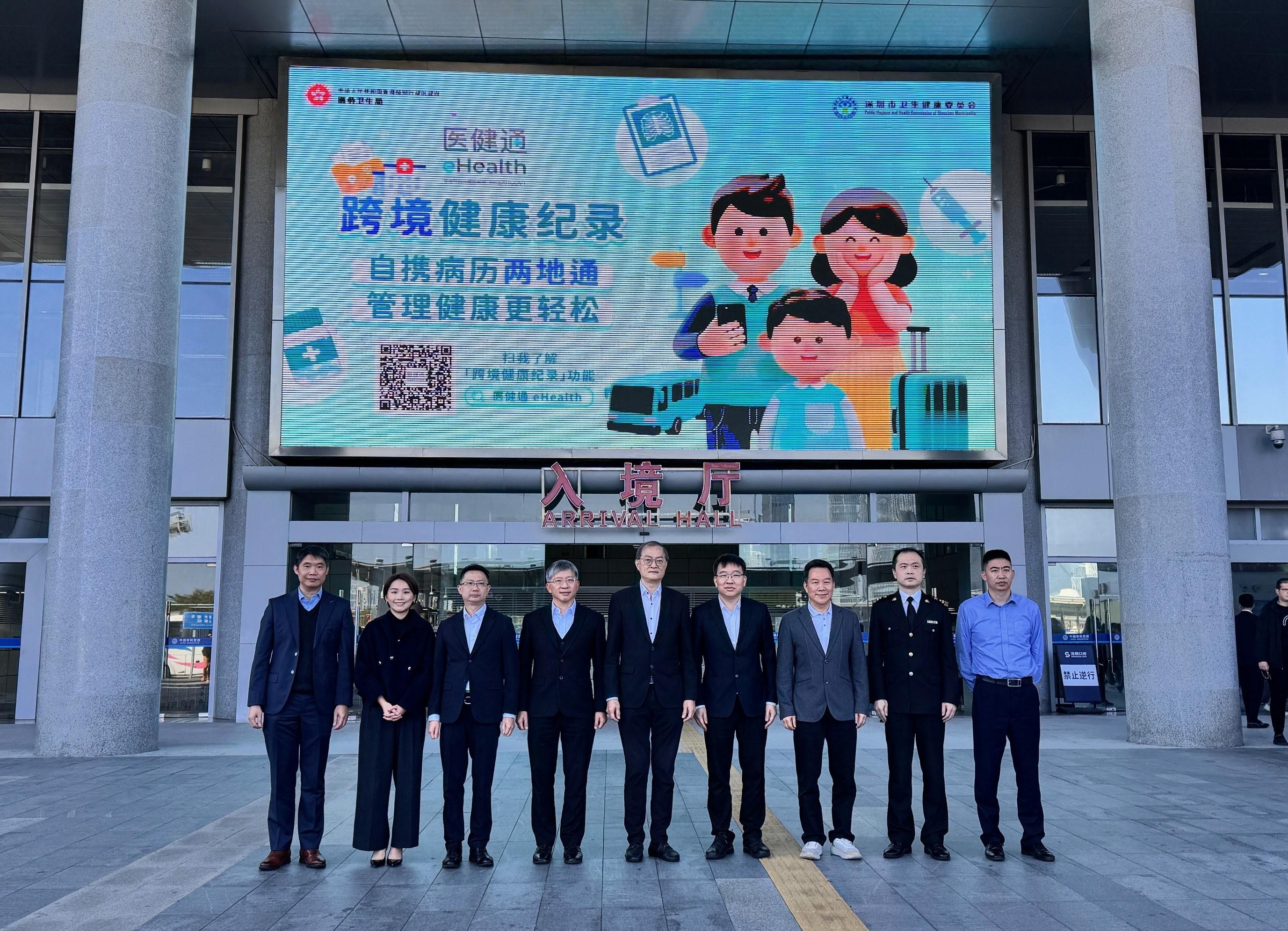 The Secretary for Health, Professor Lo Chung-mau, and Deputy Director of the Public Hygiene and Health Commission of Shenzhen Municipality Mr Li Chuang, met in Shenzhen today (February 11) to further deepen healthcare collaboration between Shenzhen and Hong Kong. Photo shows Professor Lo (centre); Mr Li (fourth right); the Permanent Secretary for Health, Mr Thomas Chan (fourth left); the Senior Advisor (Secretary for Health's Office), Dr Joe Fan (third left), and other government personnel of the two places with a promotional screen displaying message of eHealth's cross-boundary health records at the Shenzhen Bay Port.