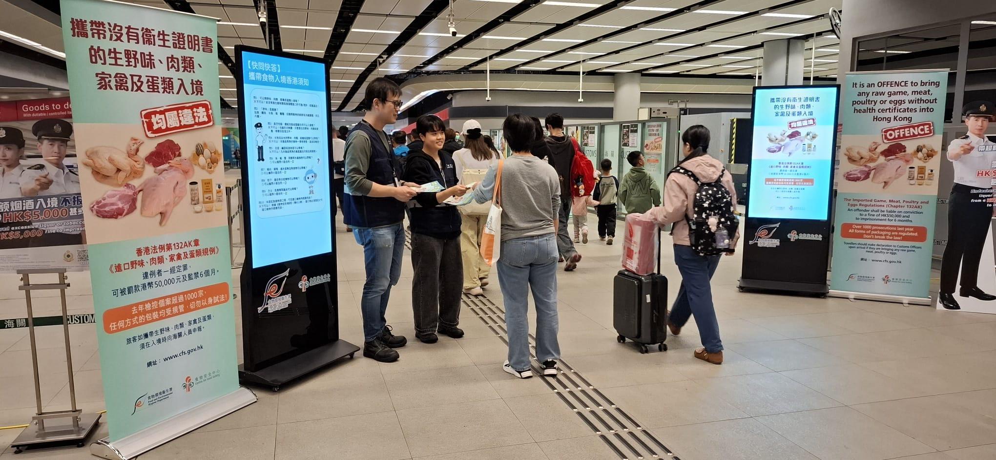 With the Chinese New Year approaching, the Centre for Food Safety (CFS) of the Food and Environmental Hygiene Department today (February 13) reminded members of the public not to illegally bring regulated food, such as raw meat, poultry and eggs, from the Mainland or overseas into Hong Kong. Photo shows CFS officers distributing leaflets at a boundary control point to remind inbound travellers and the public to abide the relevant regulations.