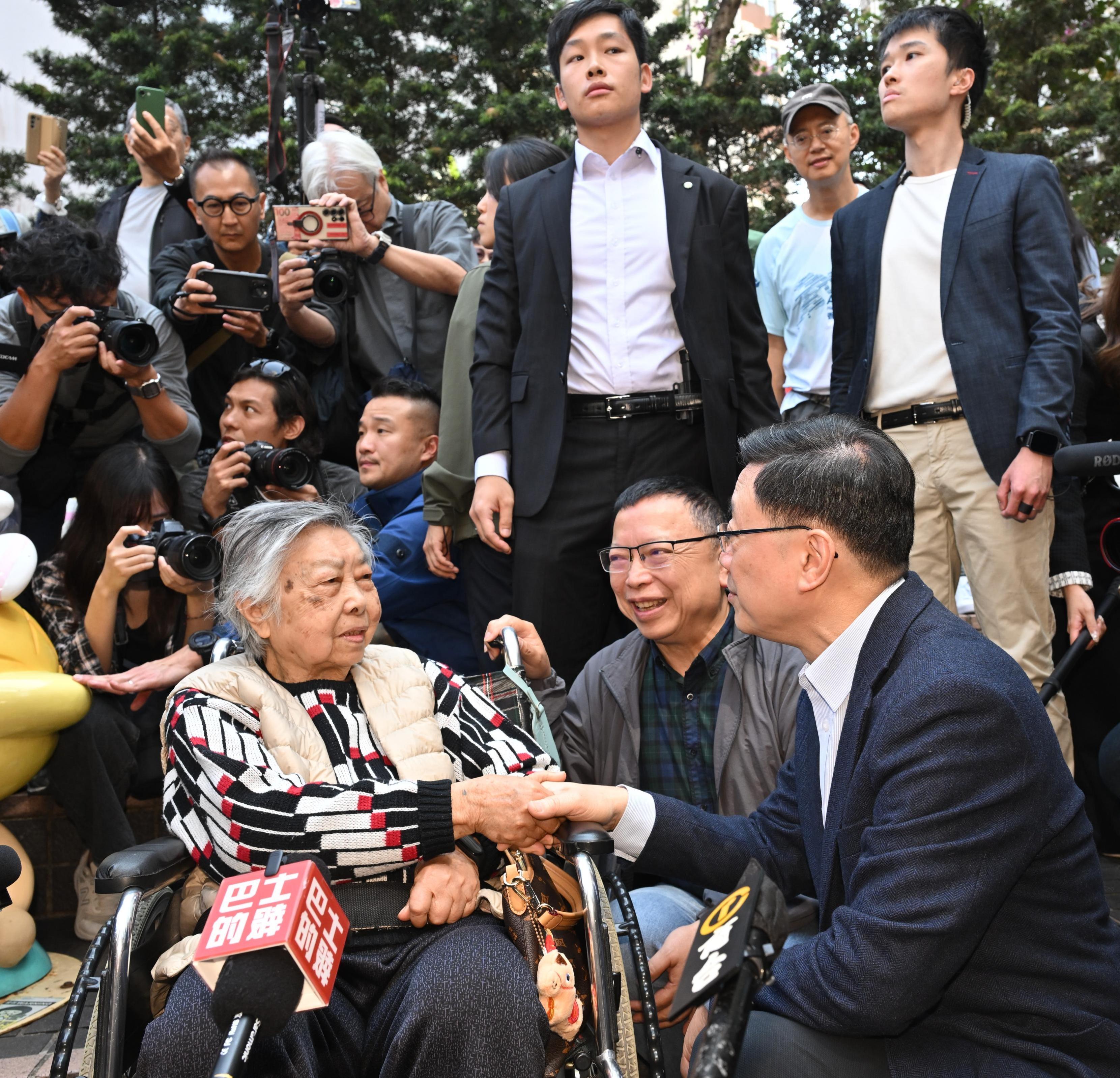 The Chief Executive, Mr John Lee, visited Yau Ma Tei today (February 13). Photo shows Mr Lee (first right) visiting Yau Ma Tei and interacting with an elderly person.