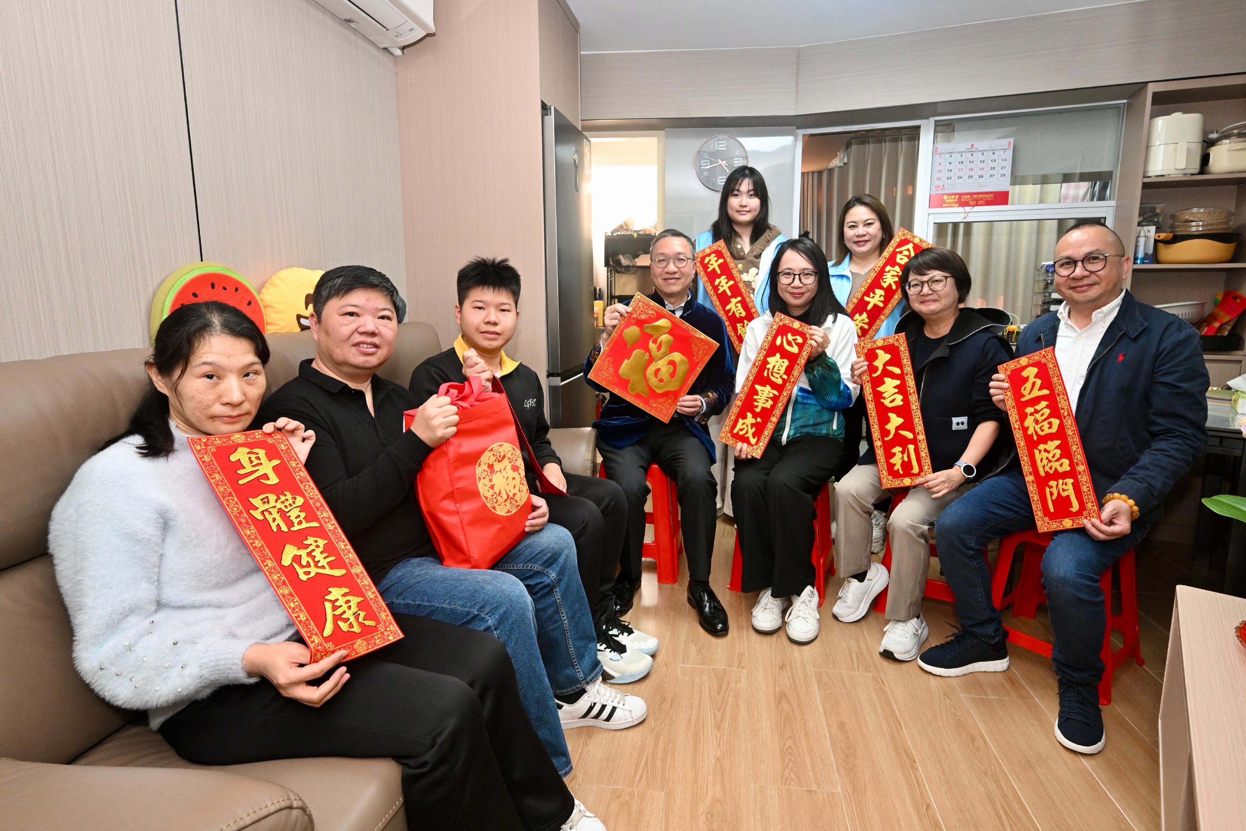 律政司司長林定國資深大律師（左四）在灣仔民政事務專員張雁伶（右三）陪同下，探訪居於勵德邨的青年家庭，與他們親切交流，送上新春祝福。