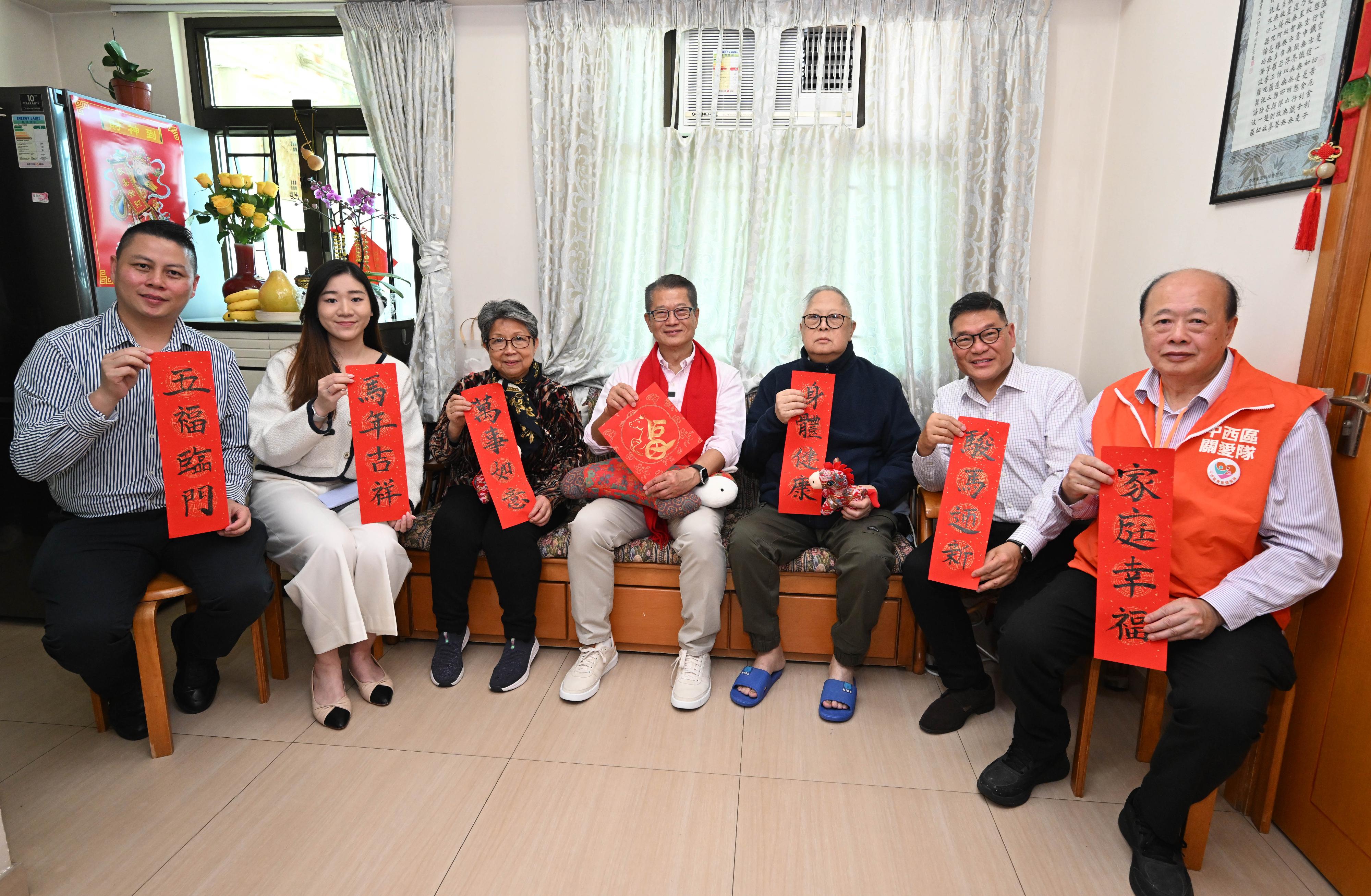 The Financial Secretary, Mr Paul Chan (centre), accompanied by the Acting District Officer (Central and Western), Miss Enson Chow (second left), visits a family living in Sai Wan in warm conversations and send them greetings.