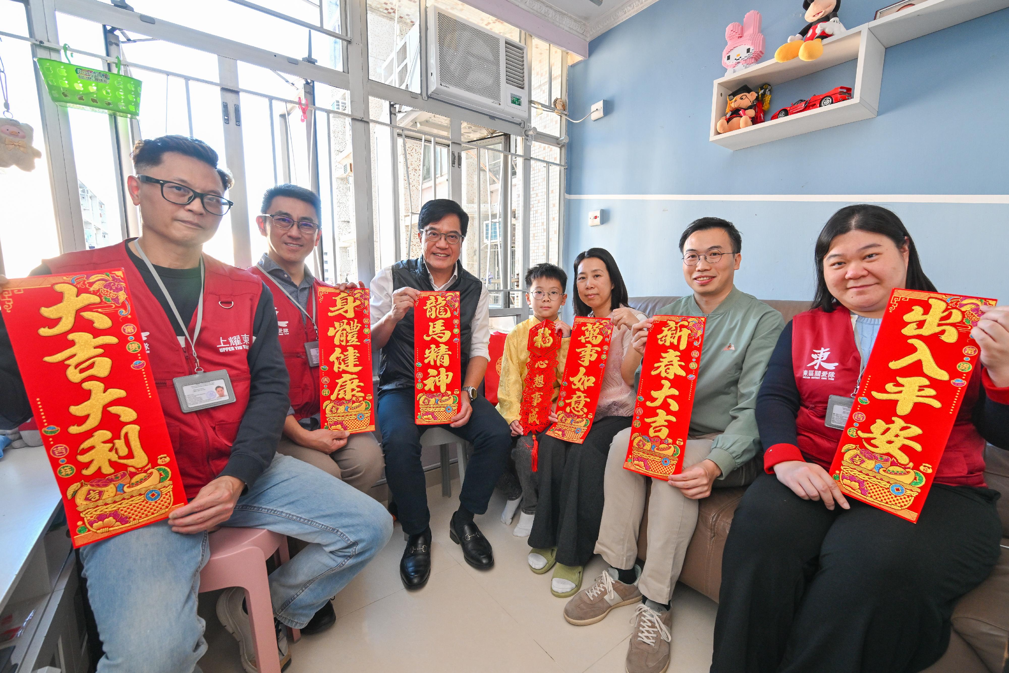 The Deputy Financial Secretary, Mr Michael Wong (third left), accompanied by the District Officer (Eastern), Mr Henry Lai (second right), together with District Council member and representatives from the Care Team of Eastern District, visited a family living in Yiu Tung Estate today (February 14) to learn about their daily lives and extend Chinese New Year wishes.
