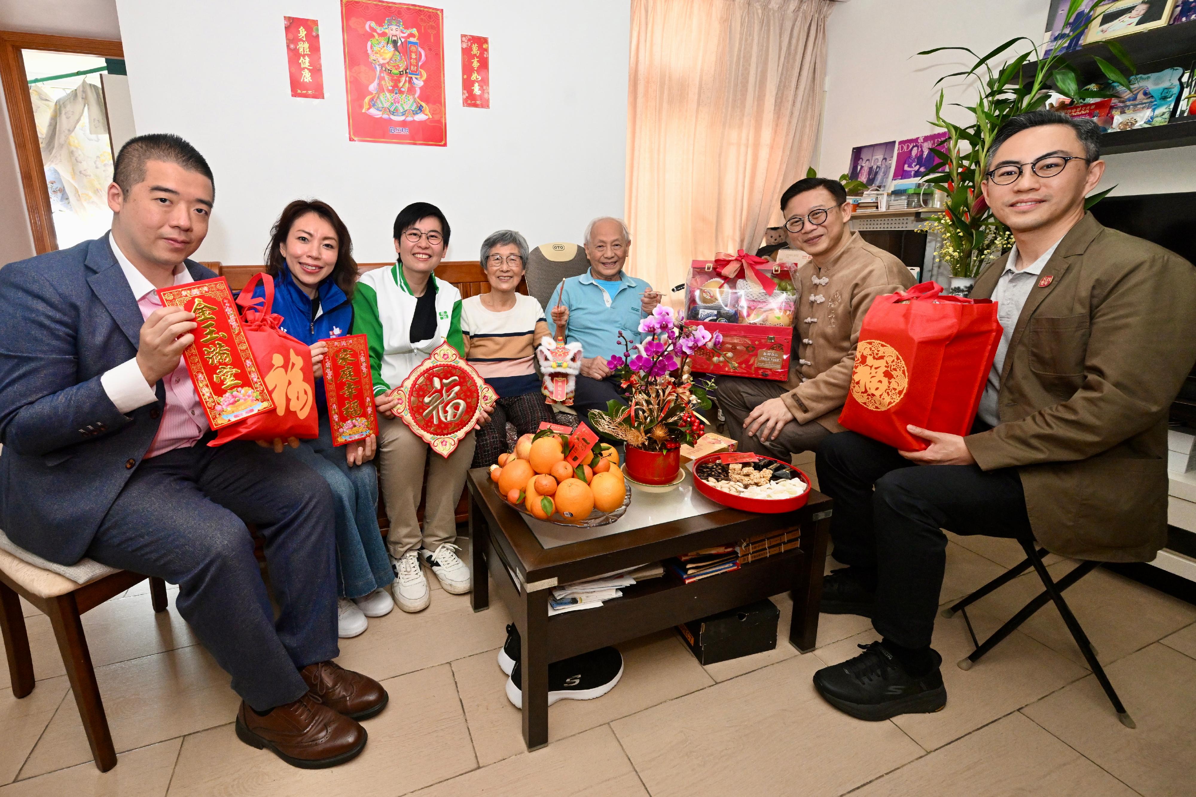 律政司副司長張國鈞博士（右二）今日（二月十六日）在沙田民政事務專員余懷誠（右一）陪同下，聯同沙田區區議員和地區服務及關愛隊伍代表，探訪居於恆安邨的基層家庭，關心他們的居住和生活狀況，並送贈賀年福袋。