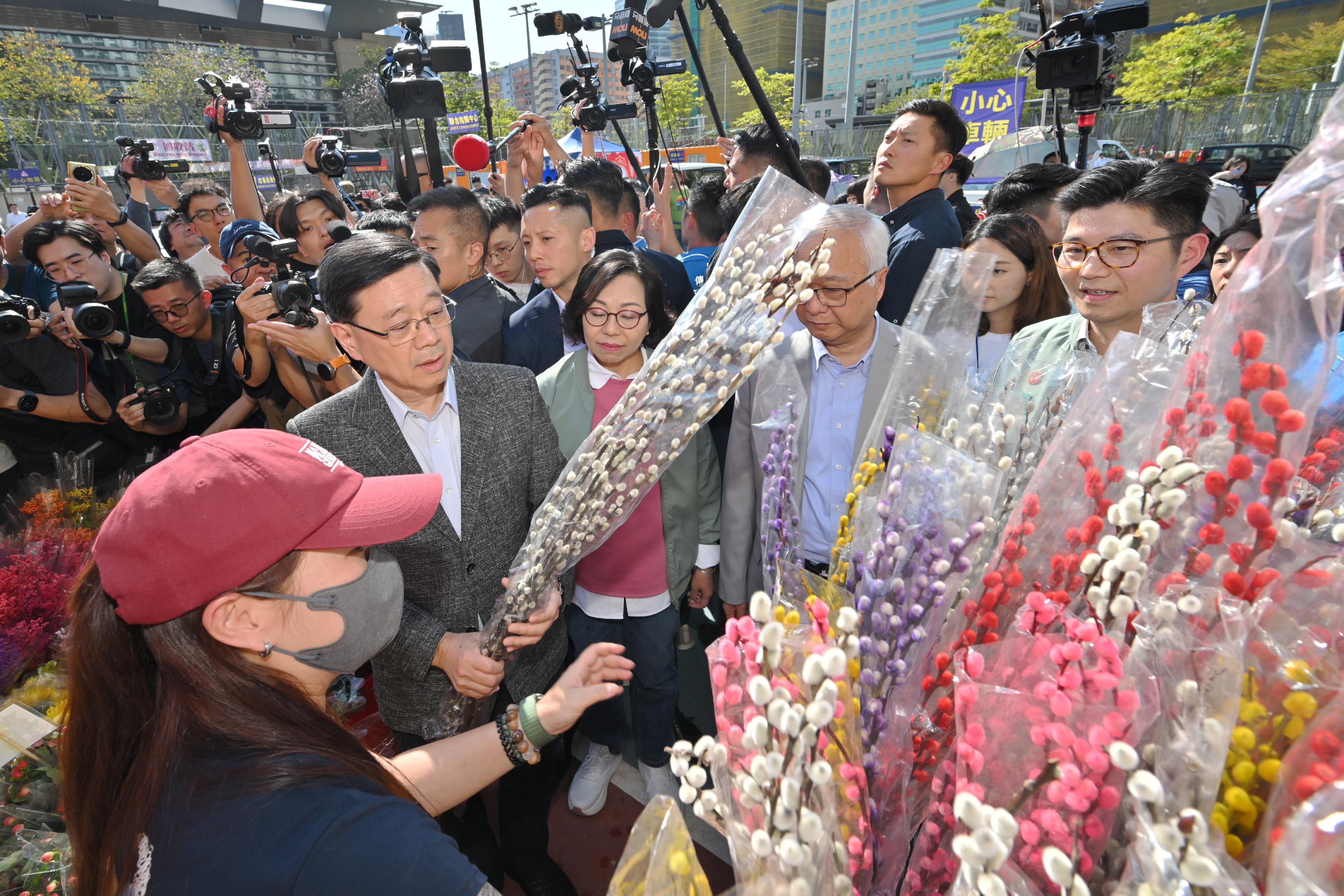 行政長官李家超今日（二月十六日）到訪觀塘遊樂場農曆新年年宵市場。圖示李家超（左二）購買年花。