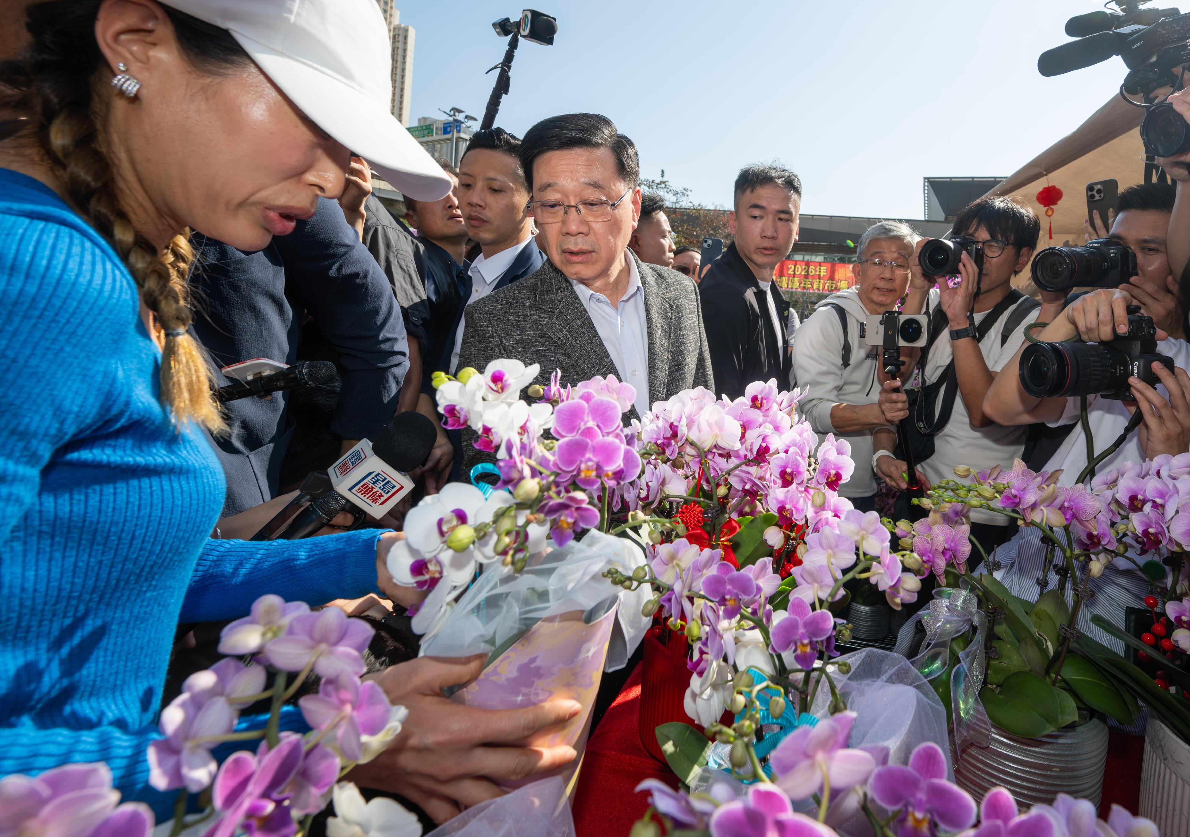 行政長官李家超今日（二月十六日）到訪觀塘遊樂場農曆新年年宵市場。圖示李家超（左二）購買年花。