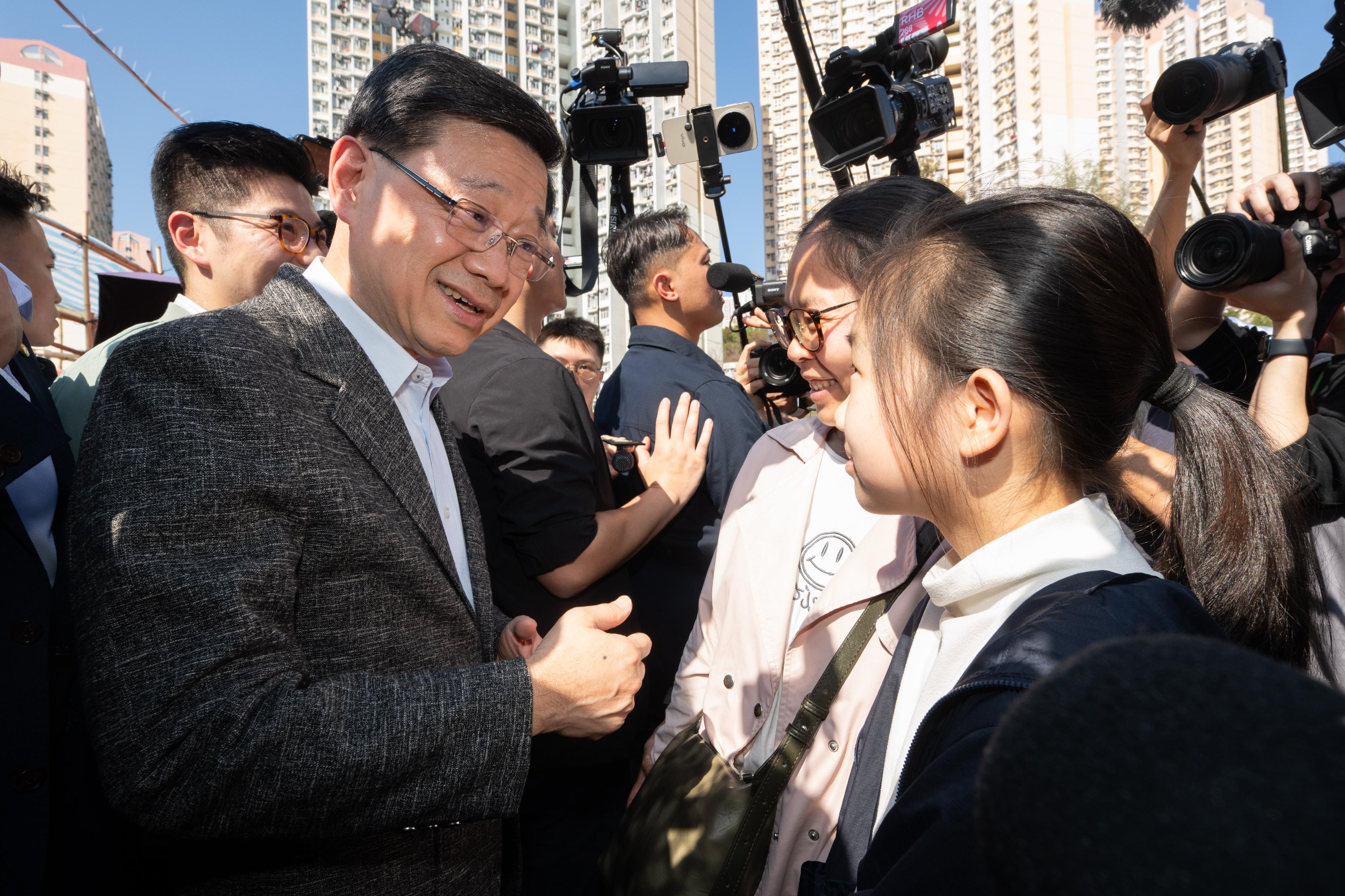 行政長官李家超今日（二月十六日）到訪觀塘遊樂場農曆新年年宵市場。圖示李家超（左一）與市民交流。