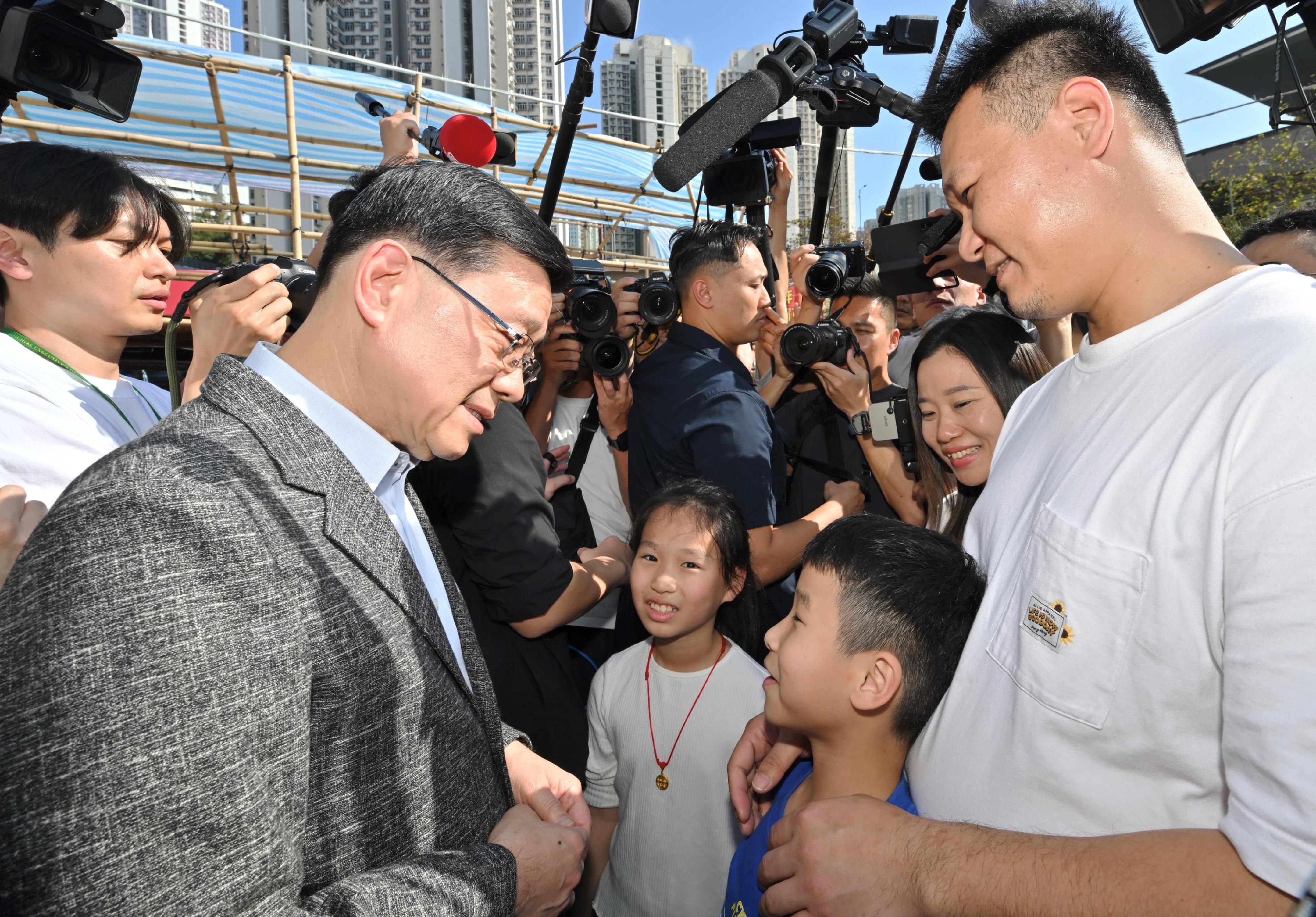 行政長官李家超今日（二月十六日）到訪觀塘遊樂場農曆新年年宵市場。圖示李家超（左一）與市民交流。