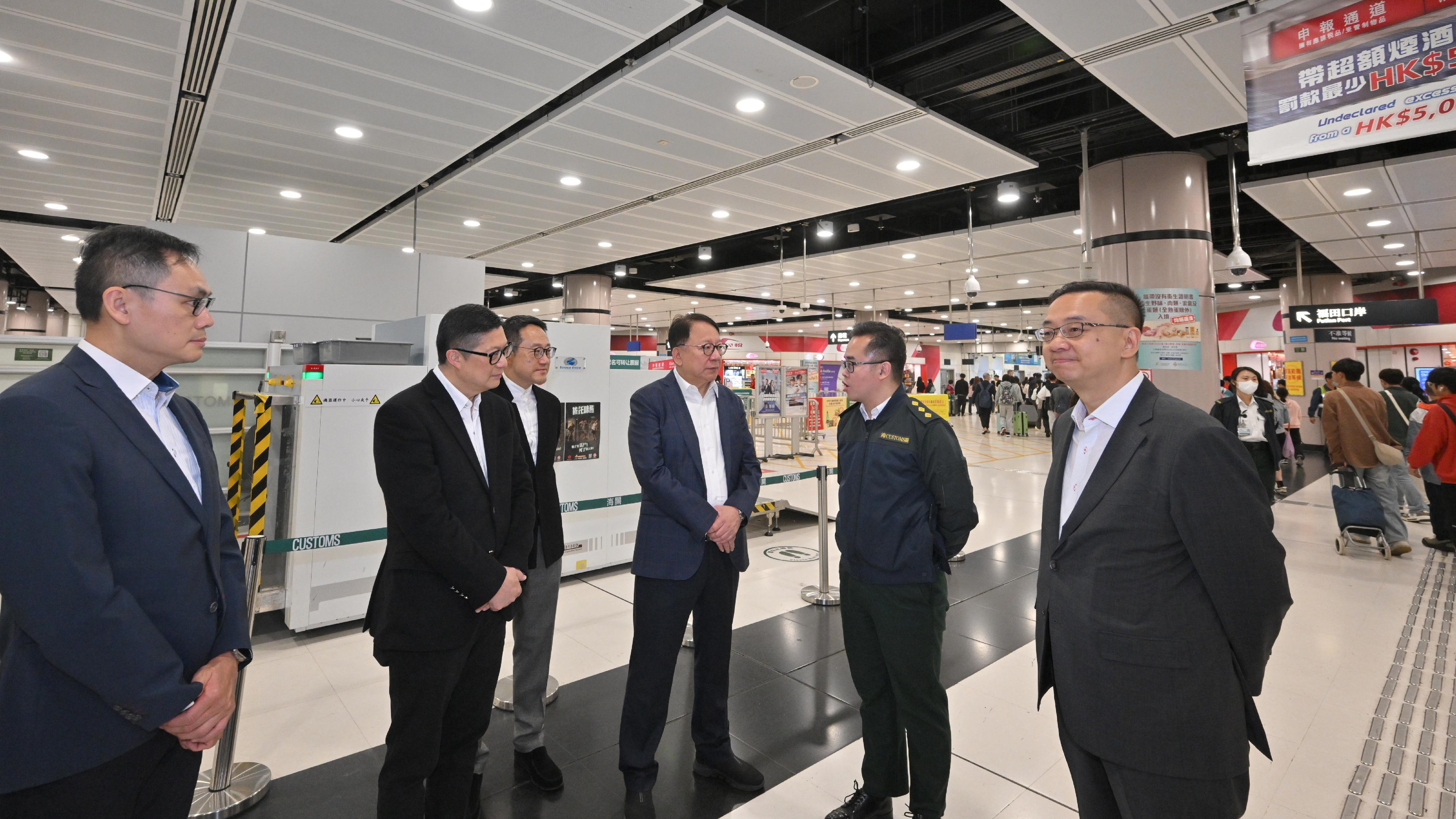 The Chief Secretary for Administration, Mr Chan Kwok-ki (third right), accompanied by the Secretary for Security, Mr Tang Ping-keung (second left), the Director of Immigration, Mr Benson Kwok (first right); and the Commissioner of Customs and Excise, Mr Chan Tsz-tat (third left), inspects the Lok Ma Chau Spur Line Control Point as he receives a briefing from staff of the Customs and Excise Department today (February 17), the first day of the Chinese New Year. He also thanked all the colleagues on duty during the Chinese New Year holidays.