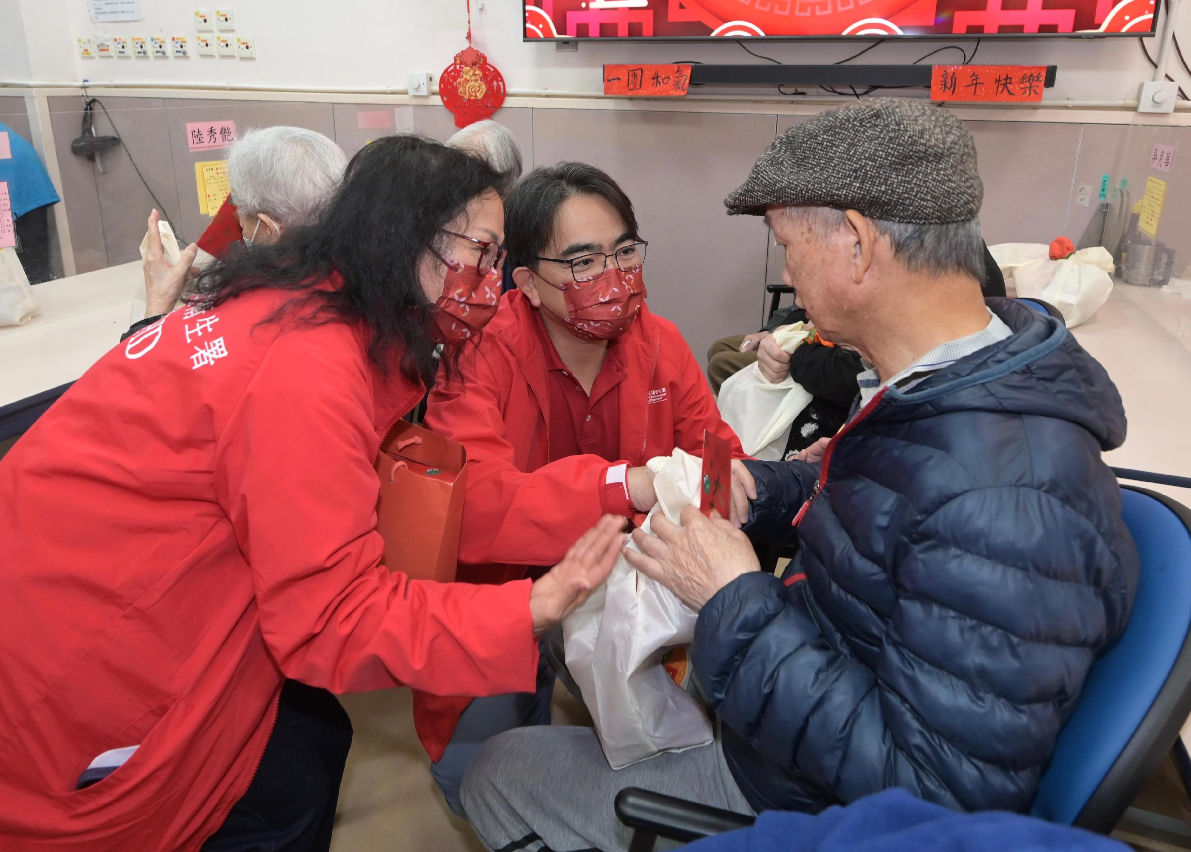 The 2026 Lunar New Year (LNY) fairs concluded successfully at 7am today (February 17). Volunteer teams made up of the Food and Environmental Hygiene Department staff assisted the department to deliver unsold pots of flowers and plants donated by LNY fair licensees to elderly home/residential care homes for person with disabilities and public hospitals. Photo shows the Director of Food and Environmental Hygiene, Mr Donald Ng (centre) and volunteers extending New Year greetings to elderly persons at a residential care home for the elderly.