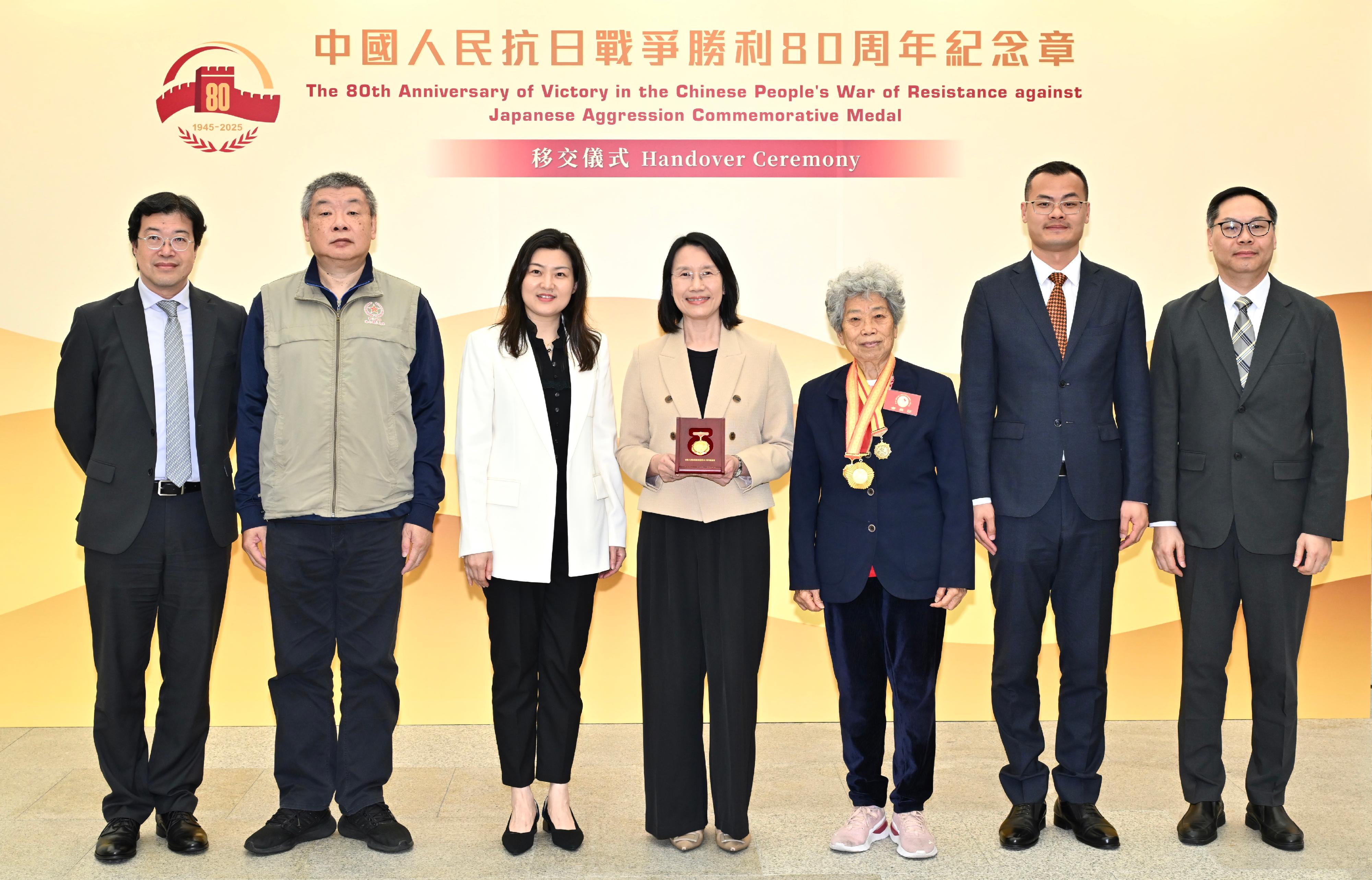 香港特別行政區政府今日（二月二十六日）於香港抗戰及海防博物館舉行「中國人民抗日戰爭勝利80周年紀念章」移交儀式。圖示康樂及文化事務署（康文署）署長陳詠雯（中）、國務院港澳事務辦公室（港澳辦）五局副局長李麗（左三）、原東江縱隊港九獨立大隊老游擊戰士聯誼會會長林珍（右三）、副會長林鳴（左二）、港澳辦五局一處調研員劉萌（右二）、康文署助理署長（文博）伍志和（左一）和弘揚中華文化辦公室總監張銳森（右一）參與儀式。