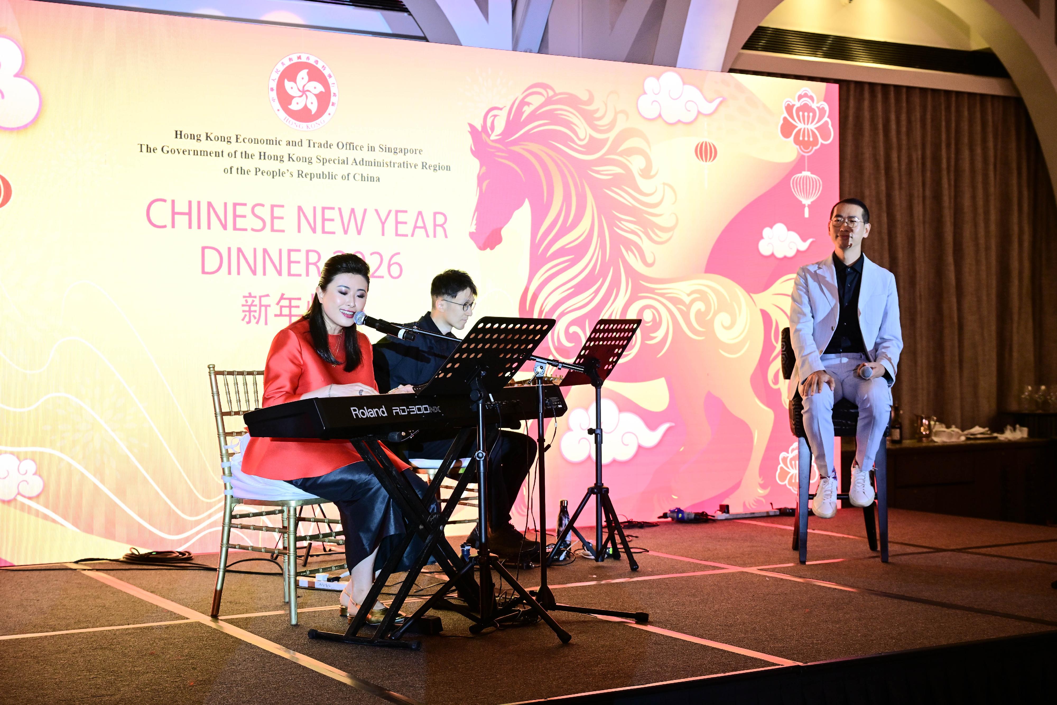 The Hong Kong Economic and Trade Office, Singapore hosted a dinner at the Fullerton Bay Hotel Singapore yesterday (February 25) to celebrate the Year of the Horse with the Singapore community and promote Hong Kong. Photo shows Hong Kong musicians Anna Lo (first left) and Rick Lau (first right), who performed as guest artistes, presenting a selection of the widely acclaimed Hong Kong cabaret production "LauZone". Through songs written in a variety of dialects, they portrayed Hong Kong's unique character as a cultural melting pot, enabling the Singapore audience to find resonance in the stories told. The duo will also take part in the Huayi - Chinese Festival of Arts 2026 organised by Esplanade - Theatres on the Bay (the Esplanade), where they will stage three performances of "LauZone" on February 27 and 28, with support from the Esplanade and the Hong Kong Arts Development Council.