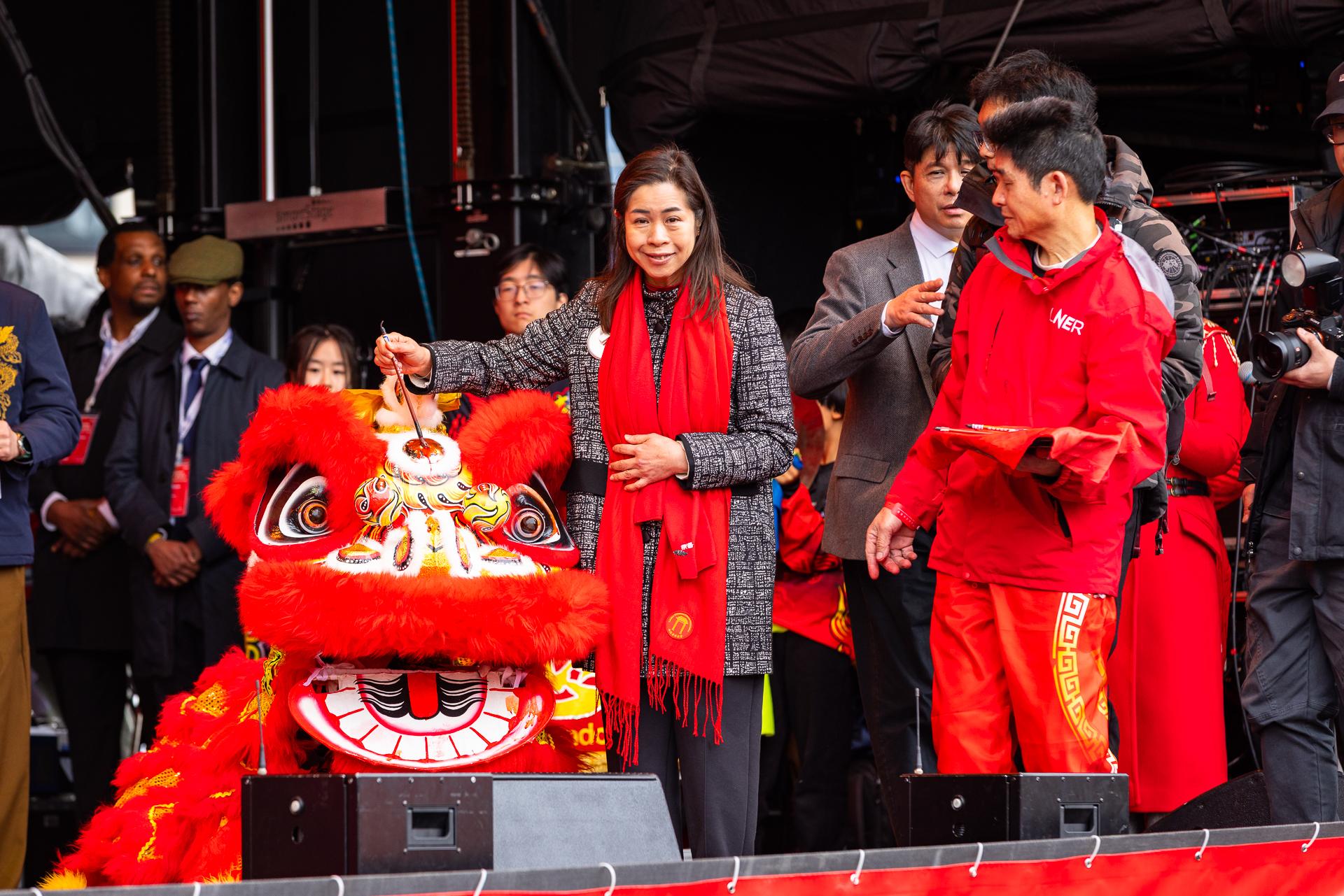 The Hong Kong Economic and Trade Office in London (London ETO) welcomed the Year of the Horse by supporting a large-scale London Chinatown celebration at Trafalgar Square, Chinatown, and Charing Cross Road in London on February 22 (London time). Photo shows the Director-General of the London ETO, Miss Fiona Chau, taking part in the eye-dotting ceremony for the lion dance performance.
