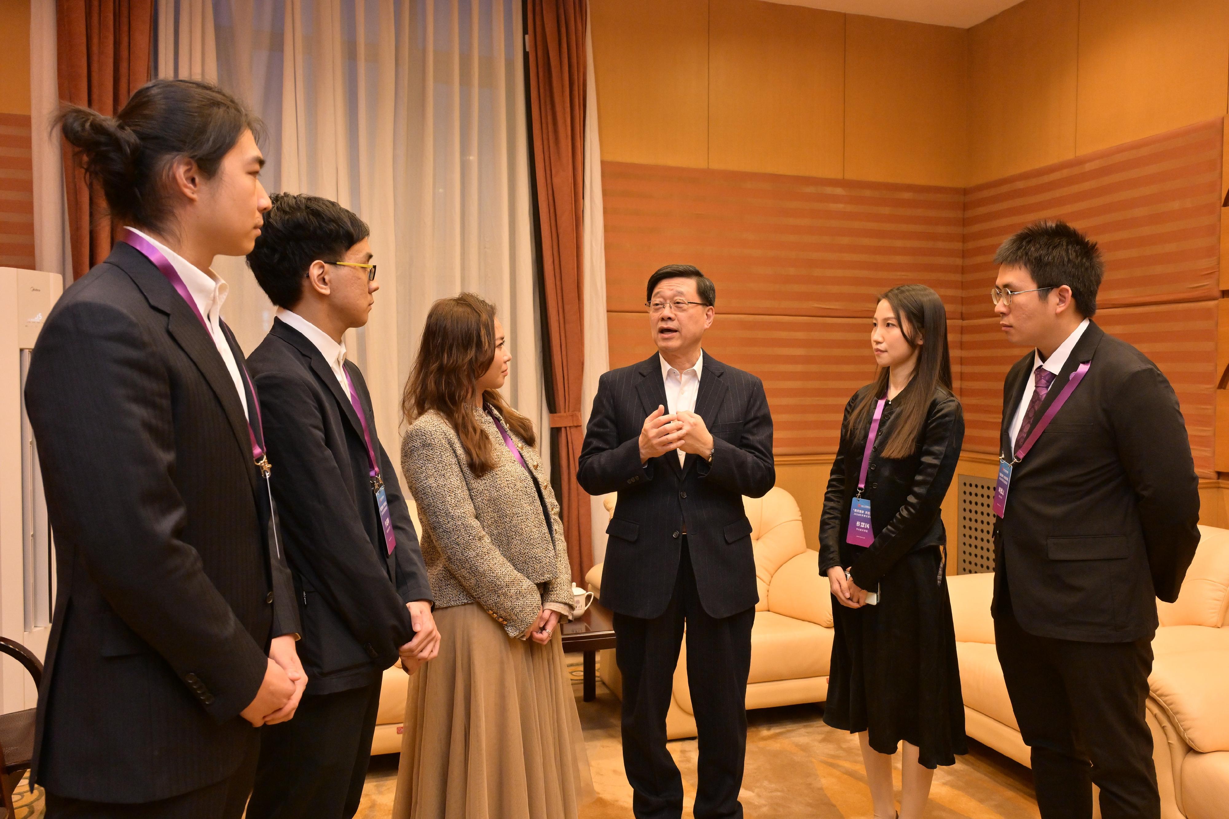 The Chief Executive, Mr John Lee, attended a seminar for Hong Kong students studying in Beijing organised by the Hong Kong Alumni Association of Beijing Universities in Beijing today (March 4). Photo shows Mr Lee (third right) exchanging views with students.