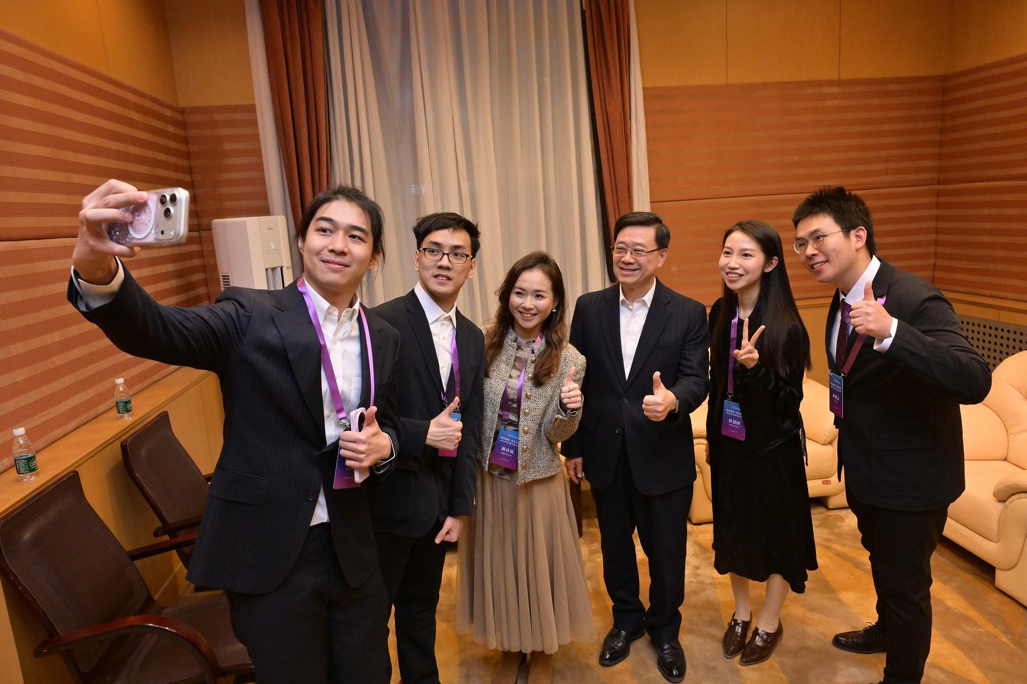 The Chief Executive, Mr John Lee, attended a seminar for Hong Kong students studying in Beijing organised by the Hong Kong Alumni Association of Beijing Universities in Beijing today (March 4). Photo shows Mr Lee (third right) exchanging views with students.