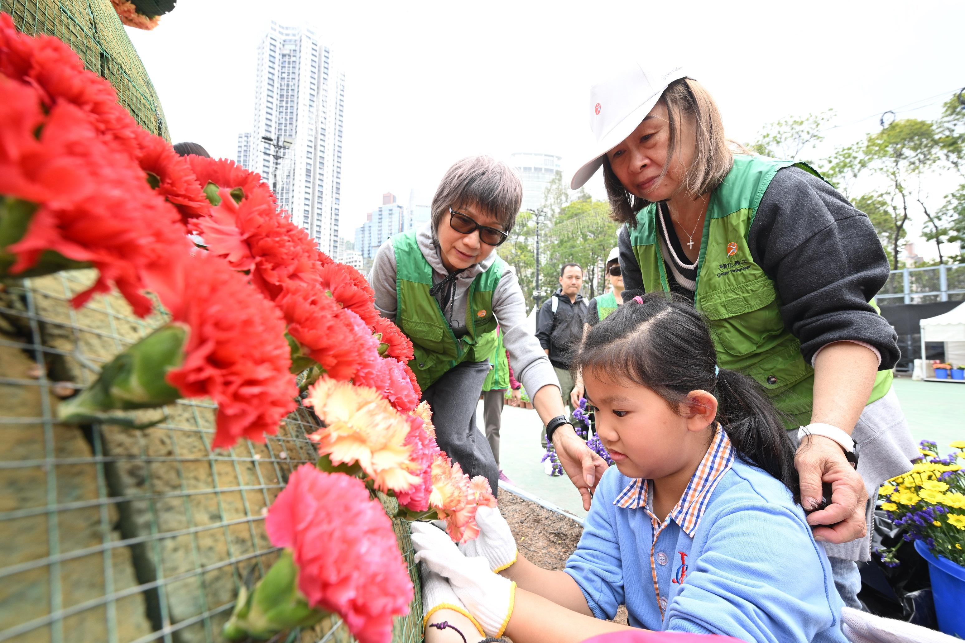 超過一千一百名來自三十八間學校的學生,今日(三月七日)於維多利亞公園參與鑲嵌花壇活動。圖示學生在綠化義工指導下鑲嵌花壇。