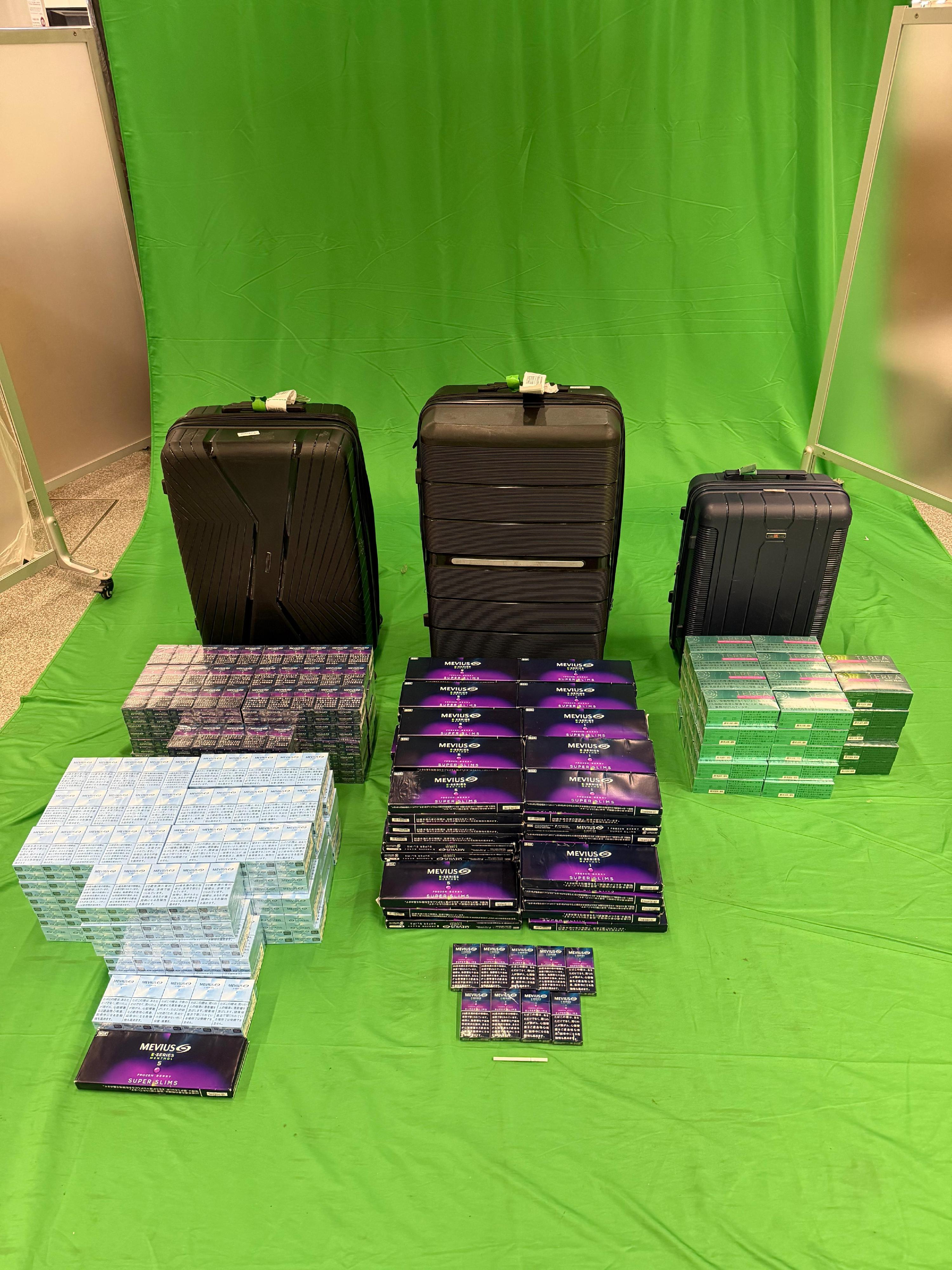 Three incoming passengers were sentenced to six months' imprisonment and fined $900, seven months' imprisonment and fined $1,000, and four months' imprisonment and fined $1,000 respectively by the West Kowloon Magistrates' Courts today (March 9) for importing duty-not-paid cigarettes, failing to declare them to Customs officers, as well as importing alternative smoking products, in contravention of the Dutiable Commodities Ordinance and the Import and Export Ordinance. Photo shows the duty-not-paid cigarettes and heat sticks seized from the personal baggage of a 33-year-old male passenger.