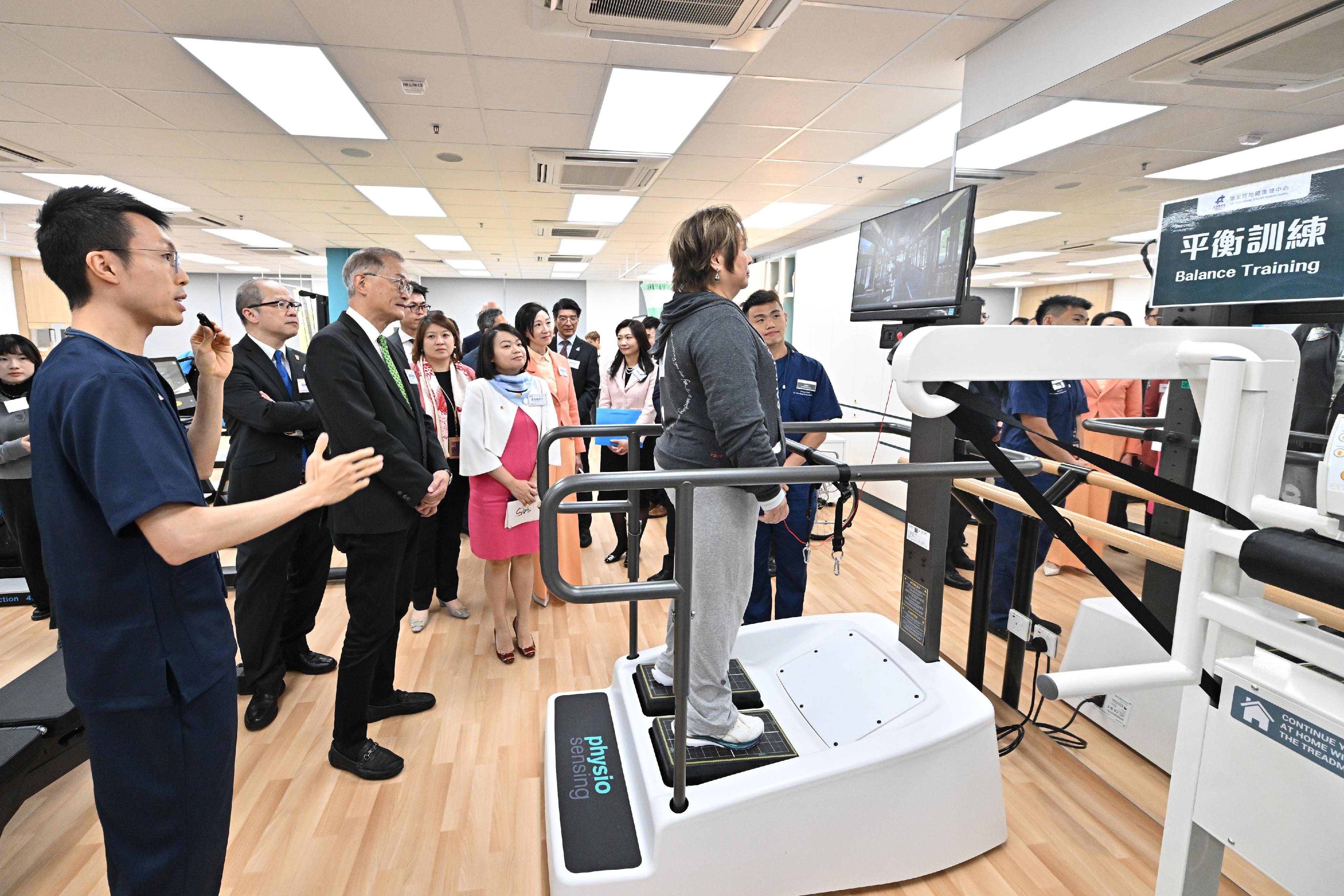 The Secretary for Health, Professor Lo Chung-mau, officiated at the Opening Ceremony of the Yau Tsim Mong District Health Centre (YTM DHC) cum Launch Ceremony of the Primary Healthcare Co-care Network today (March 13). Photo shows Professor Lo (third left) listening to the briefing by the staff of the YTM DHC on a member conducting balance training. Also present are the Under Secretary for Health, Dr Cecilia Fan (sixth left); the Commissioner for Primary Healthcare, Dr Pang Fei-chau (seventh left); and the Chief Executive of the Hospital Authority, Dr Libby Lee (fourth left).
