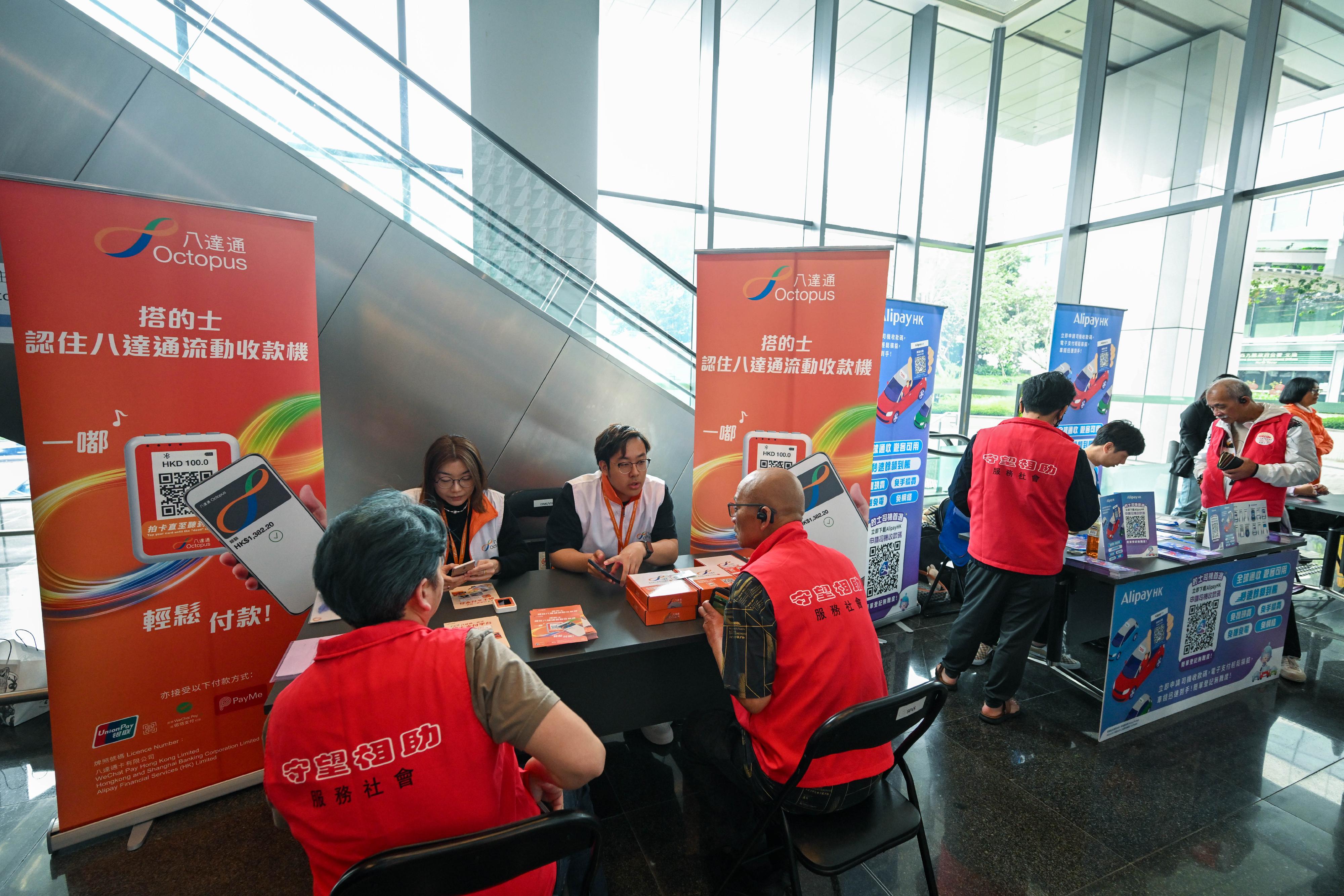 運輸署今日（三月十五日）提醒的士司機，由今年四月一日起，必須提供電子繳費媒介，以方便乘客繳付車費。乘客登車前，可留意車窗貼紙或向司機了解所提供的電子繳費媒介。乘客亦可繼續以現金繳費。署方呼籲尚未安裝電子繳費媒介的司機盡快安裝並熟習操作。圖示主要電子繳費平台在的士業界宣傳活動，向司機簡介電子繳費媒介收費操作及協助他們登記成為用戶。