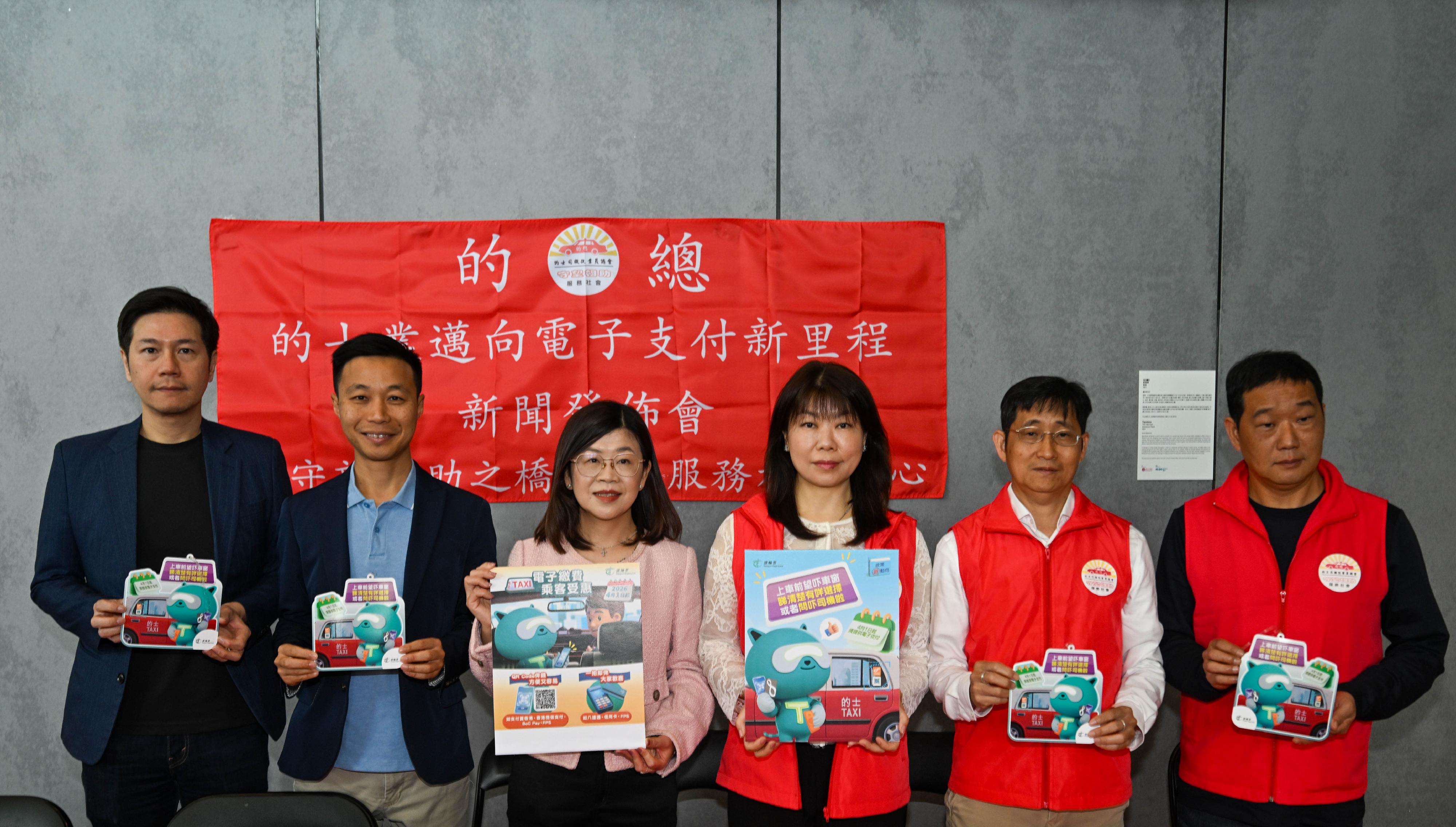 The Transport Department today (March 15) reminded taxi drivers that, starting from April 1, 2026, they must provide electronic payment means (e-payment means) to facilitate passengers' payment of taxi fares. Before boarding, passengers may check the stickers on taxi windows or ask the driver about the e-payment means available. Passengers may also continue to pay in cash. Photo shows the Assistant Commissioner for Transport/Management and Paratransit, Ms Louisa Fung (third left), and Legislative Council Members at a taxi trade publicity event, urging drivers who have yet to install e-payment means to do so as soon as possible to familiarise themselves with the operations.