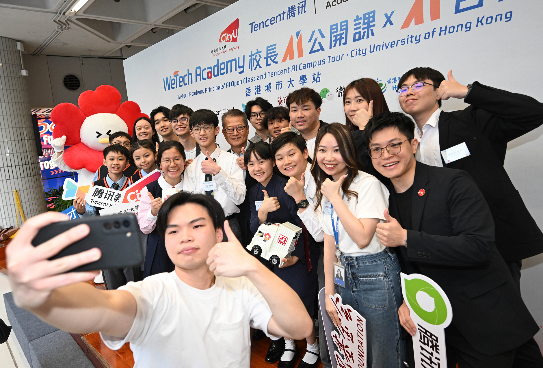 財政司司長陳茂波今日（三月十六日）出席「校長AI公開課 x AI百校行」。圖示陳茂波（後排中）參觀展覽攤位。