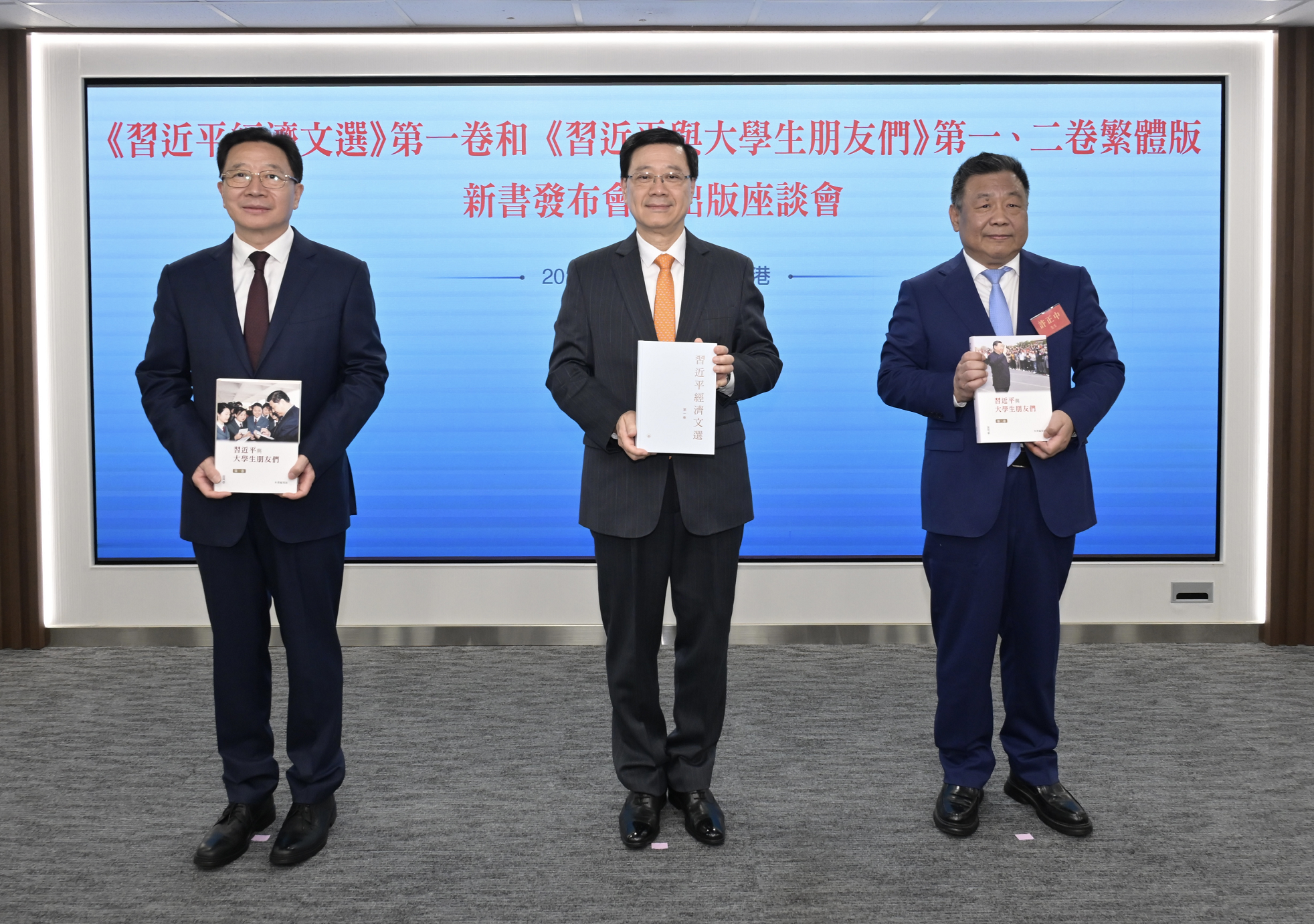 行政長官李家超今日（三月十八日）出席《習近平經濟文選》第一卷和《習近平與大學生朋友們》第一、二卷繁體版新書發布會暨出版座談會。圖示李家超（中）、中央人民政府駐香港特別行政區聯絡辦公室主任周霽（左）和紫荊文化集團董事長許正中（右）主持新書發布儀式。