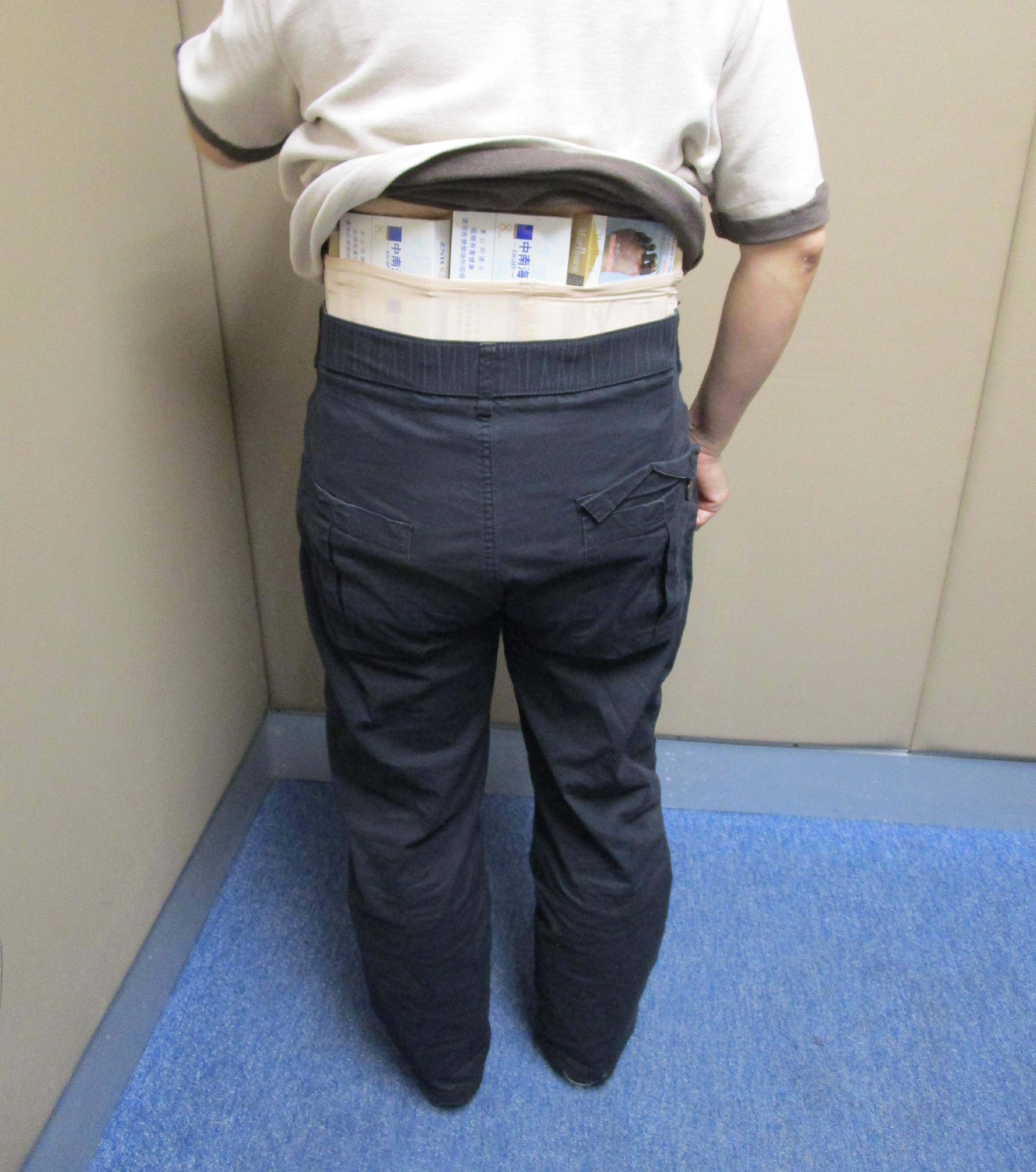 Two incoming passengers were each sentenced to six weeks' imprisonment with a fine of $3,000 by the Fanling Magistrates' Courts today (March 19) for possessing duty-not-paid cigarettes and failing to declare them to Customs officers in contravention of the Dutiable Commodities Ordinance. Photo shows a 48-year-old incoming female passenger with duty-not-paid cigarettes concealed around her waist.
