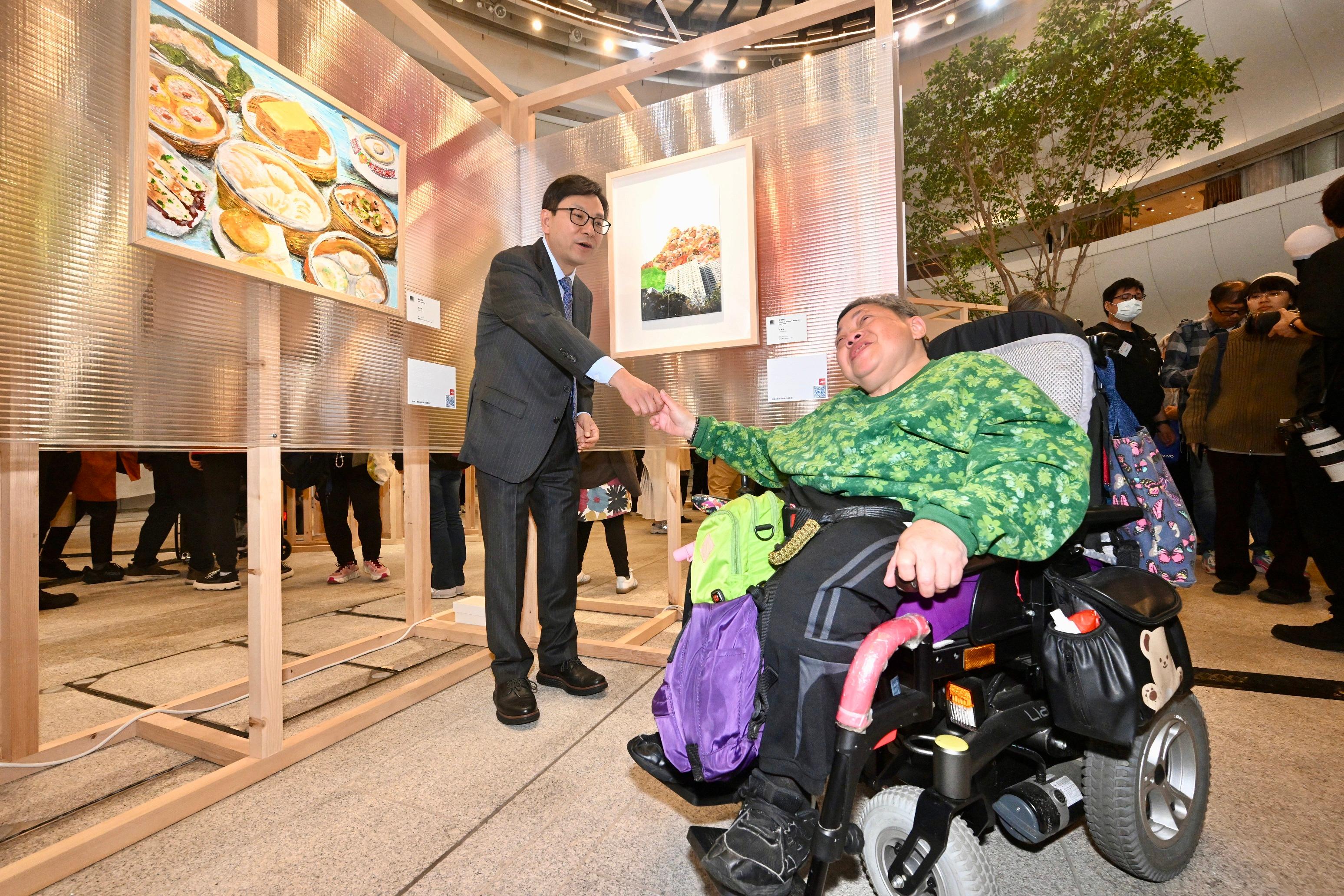 The Secretary for Labour and Welfare, Mr Chris Sun, officiated at the opening ceremony of the Diversity and Inclusion Arts Festival 2026 today (March 20). Photo shows Mr Sun (left) visiting the inclusive arts exhibition and chatting with an artist with a disability.