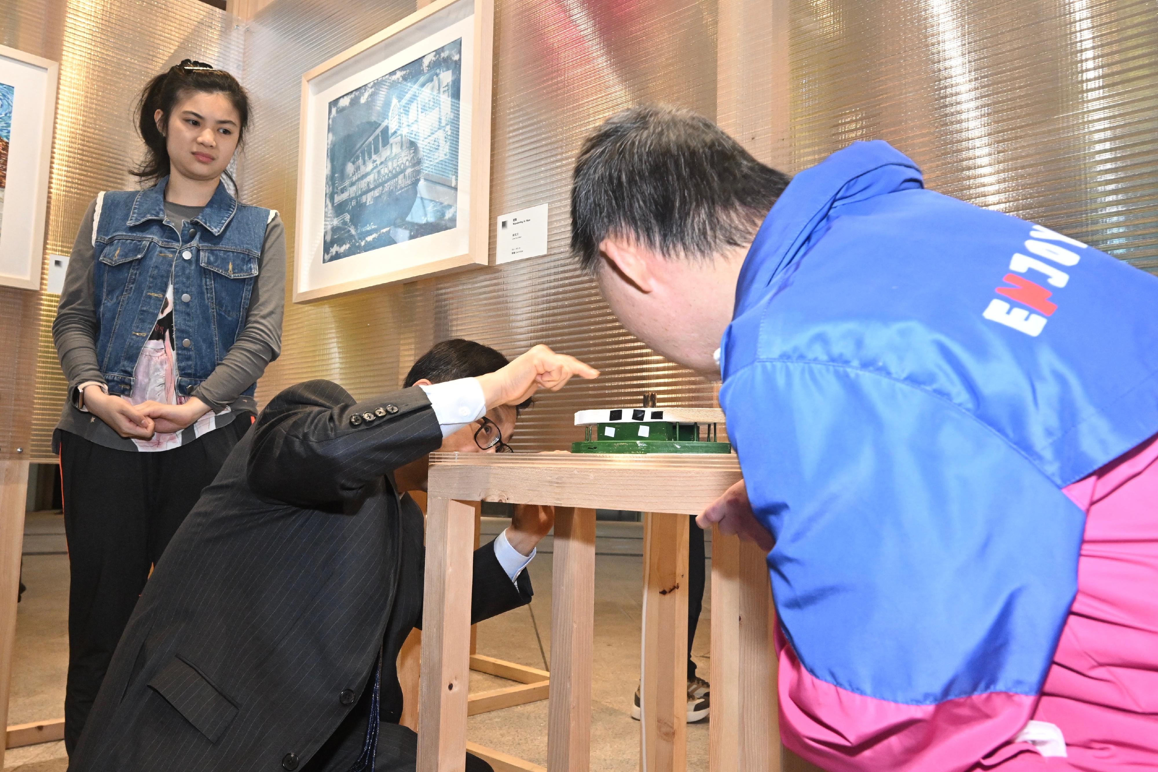 The Secretary for Labour and Welfare, Mr Chris Sun, officiated at the opening ceremony of the Diversity and Inclusion Arts Festival 2026 today (March 20). Photo shows Mr Sun (centre) engaging with an artist with a disability (right) at the inclusive arts exhibition.