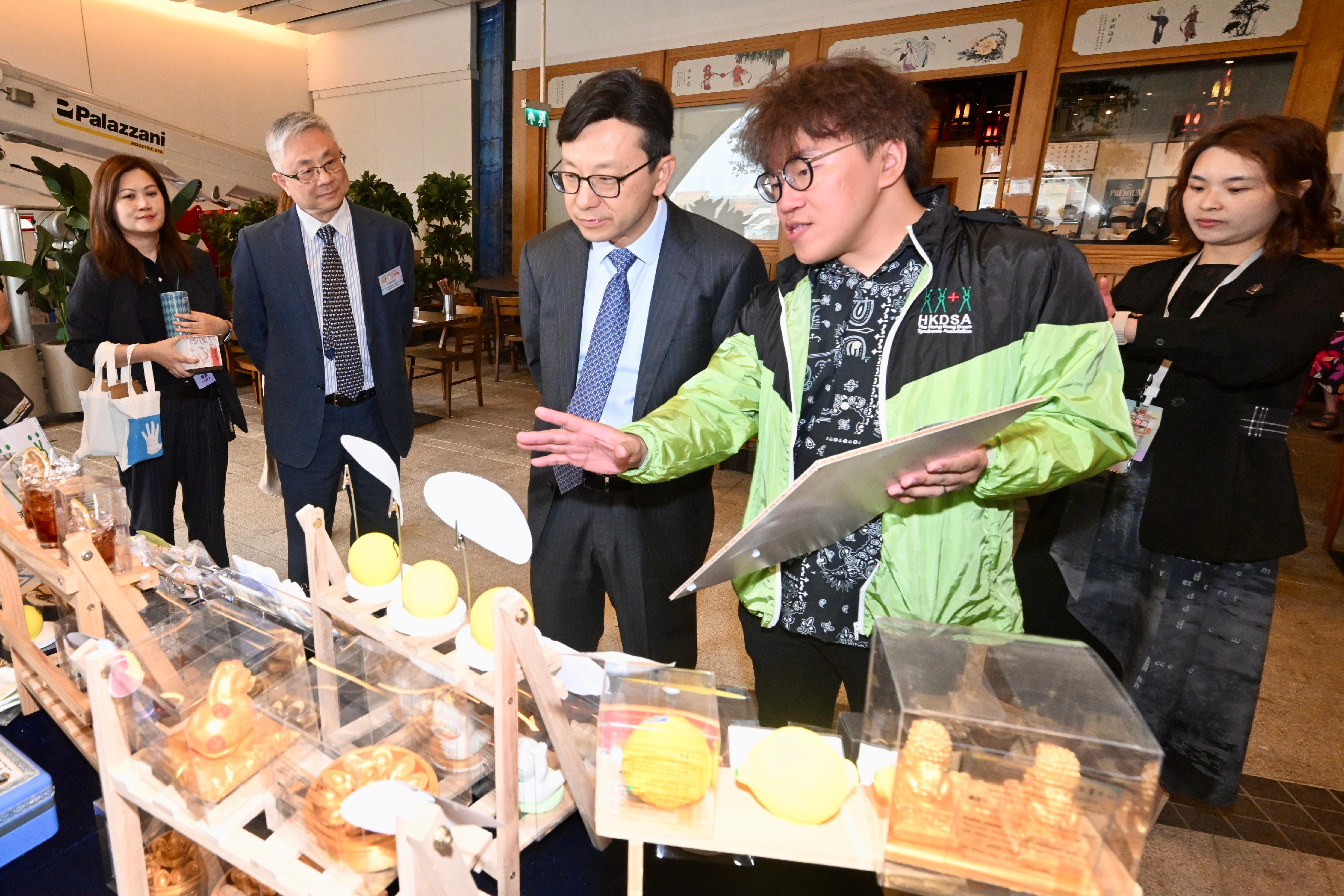 The Secretary for Labour and Welfare, Mr Chris Sun, officiated at the opening ceremony of the Diversity and Inclusion Arts Festival 2026 today (March 20). Photo shows Mr Sun (centre) visiting the arts bazaar and listening to an introduction by a staff member of an organisation.