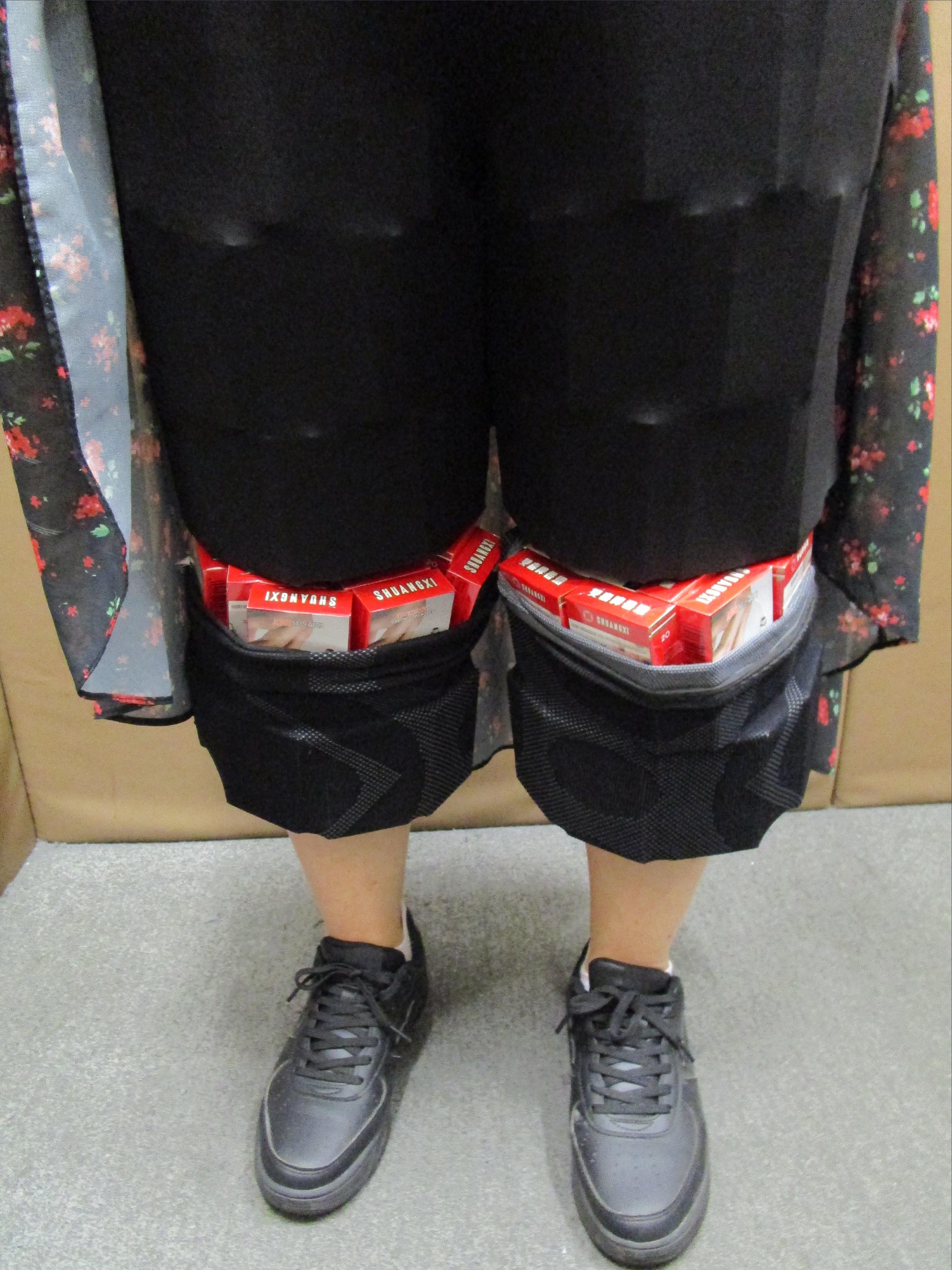 Two incoming passengers were respectively sentenced to eight weeks' imprisonment with a fine of $4,000 and four weeks&rsquo; imprisonment with a fine of $2,000 by the Fanling Magistrates' Courts today (March 20) for importing duty-not-paid cigarettes and failing to declare them to Customs officers, in contravention of Dutiable Commodities Ordinance. Photo shows a 36-year-old incoming female passenger with duty-not-paid cigarettes concealed in a pair of leggings.