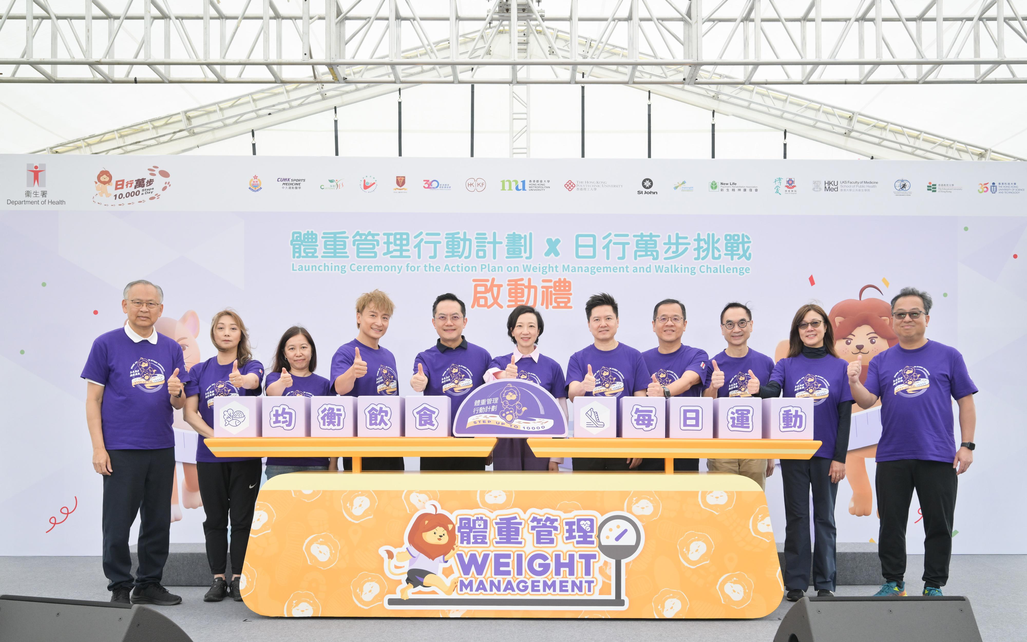 衞生署今日(三月二十一日)在西九文化區舉辦「體重管理行動計劃×日行萬步挑戰」啟動禮暨嘉年華,鼓勵市民關注自己的健康,透過日行萬步將運動融入日常生活,持續管理好自己的體重。圖示署理醫務衞生局局長范婉雯醫生(中)、衞生署署長林文健醫生(左五)、衞生署衞生防護中心總監徐樂堅醫生(右五)與其他主禮嘉賓主持啟動儀式。