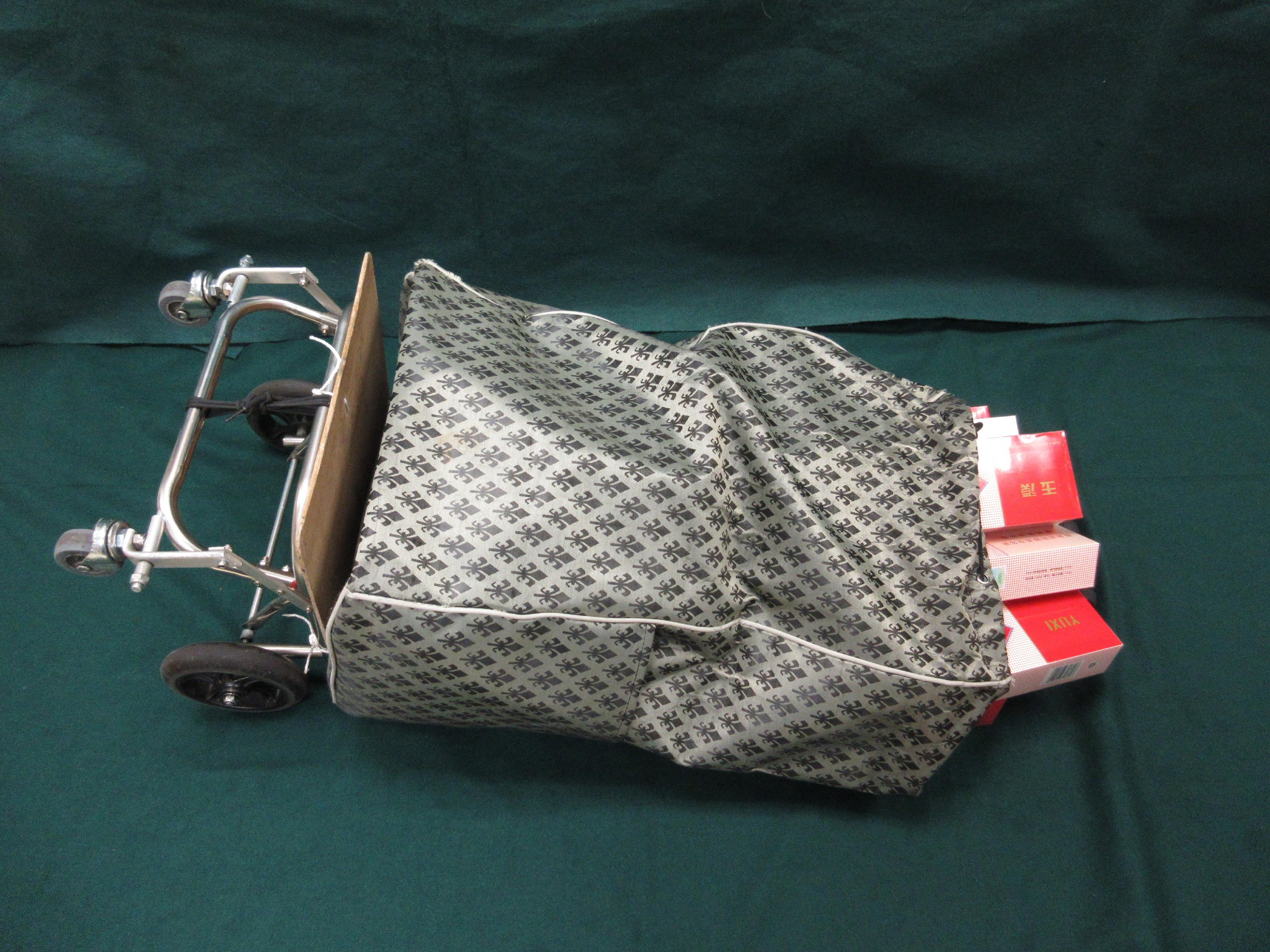 一名入境女旅客因管有未完稅香煙和未有向海關人員作出申報，違反《應課稅品條例》，今日（三月二十四日）在粉嶺裁判法院被判處監禁一個月兩星期及罰款一千元。圖示未完稅香煙被收藏在手拉車内。

