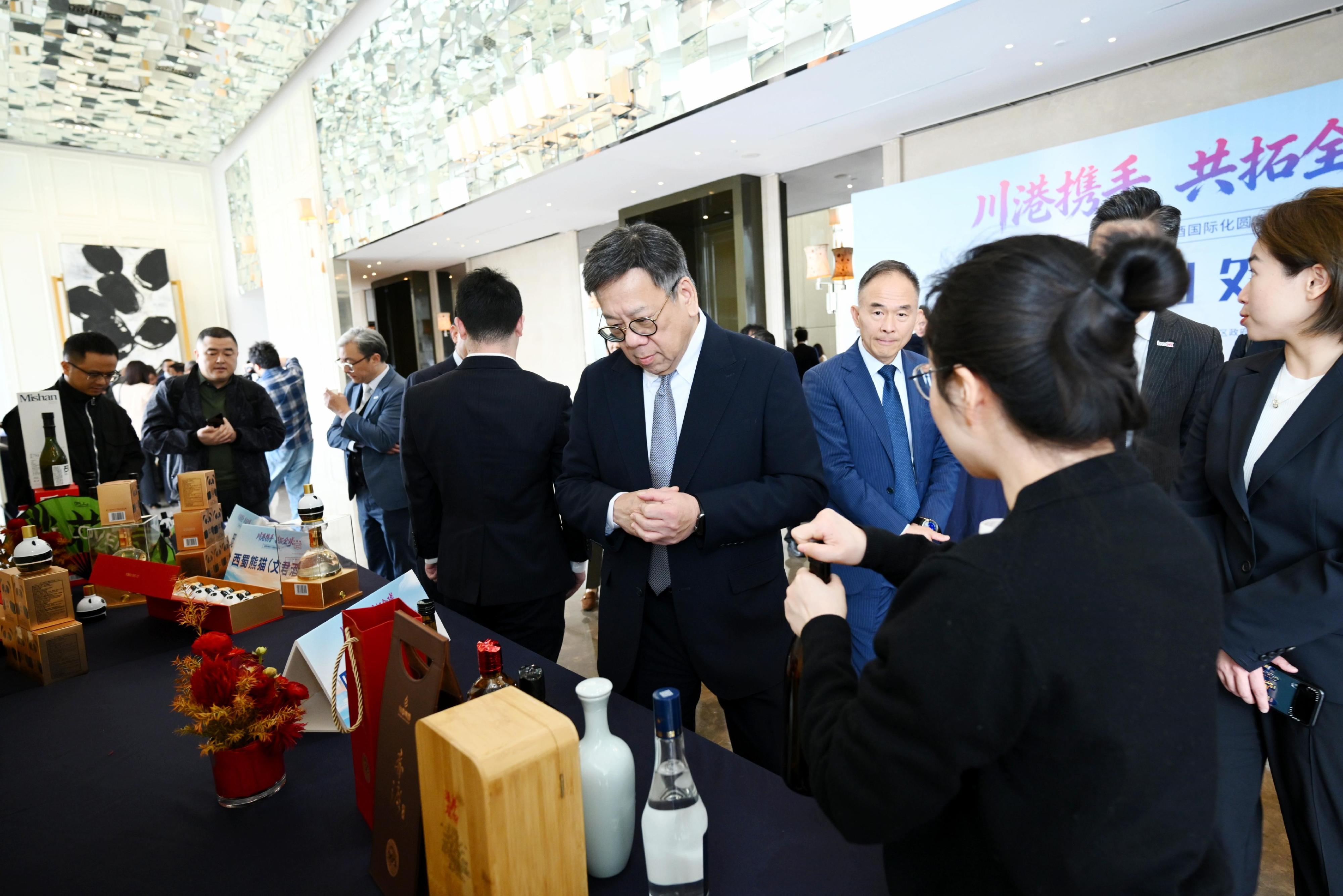 商務及經濟發展局局長丘應樺率團訪問四川推廣烈酒貿易。圖示丘應樺（右四）今日（三月二十五日）在四川成都出席川港白酒業界圓桌會議後，參觀攤位，並與當地酒業代表交流。