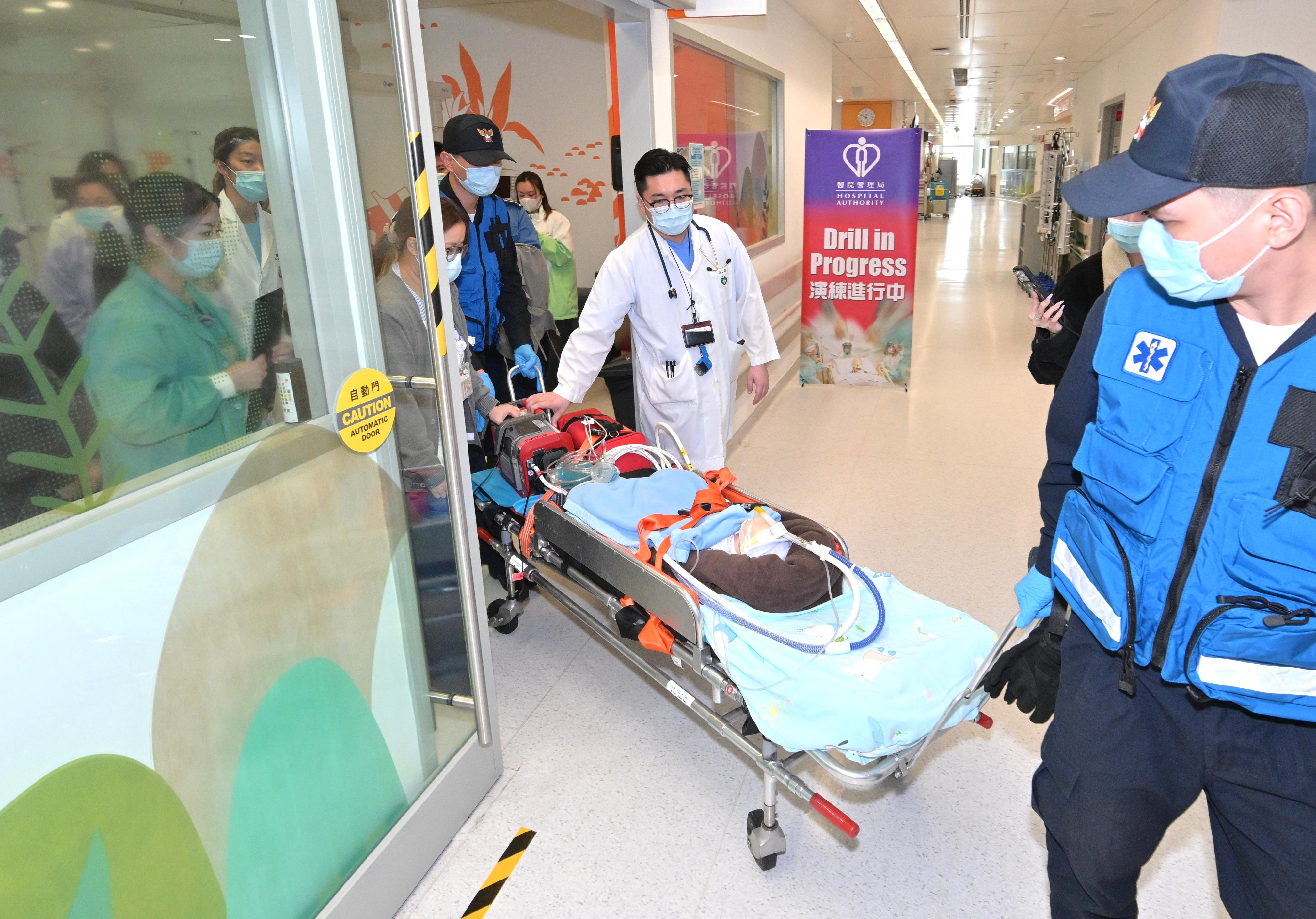 香港特別行政區政府今日（三月二十七日）公布，「大灣區跨境直通救護車試行計劃」由即日起正式與深圳、珠海和澳門實施雙向轉運安排。圖示日前參與雙向轉運演練的香港和澳門人員模擬運送病人離開香港兒童醫院病房，前往澳門仁伯爵綜合醫院。

