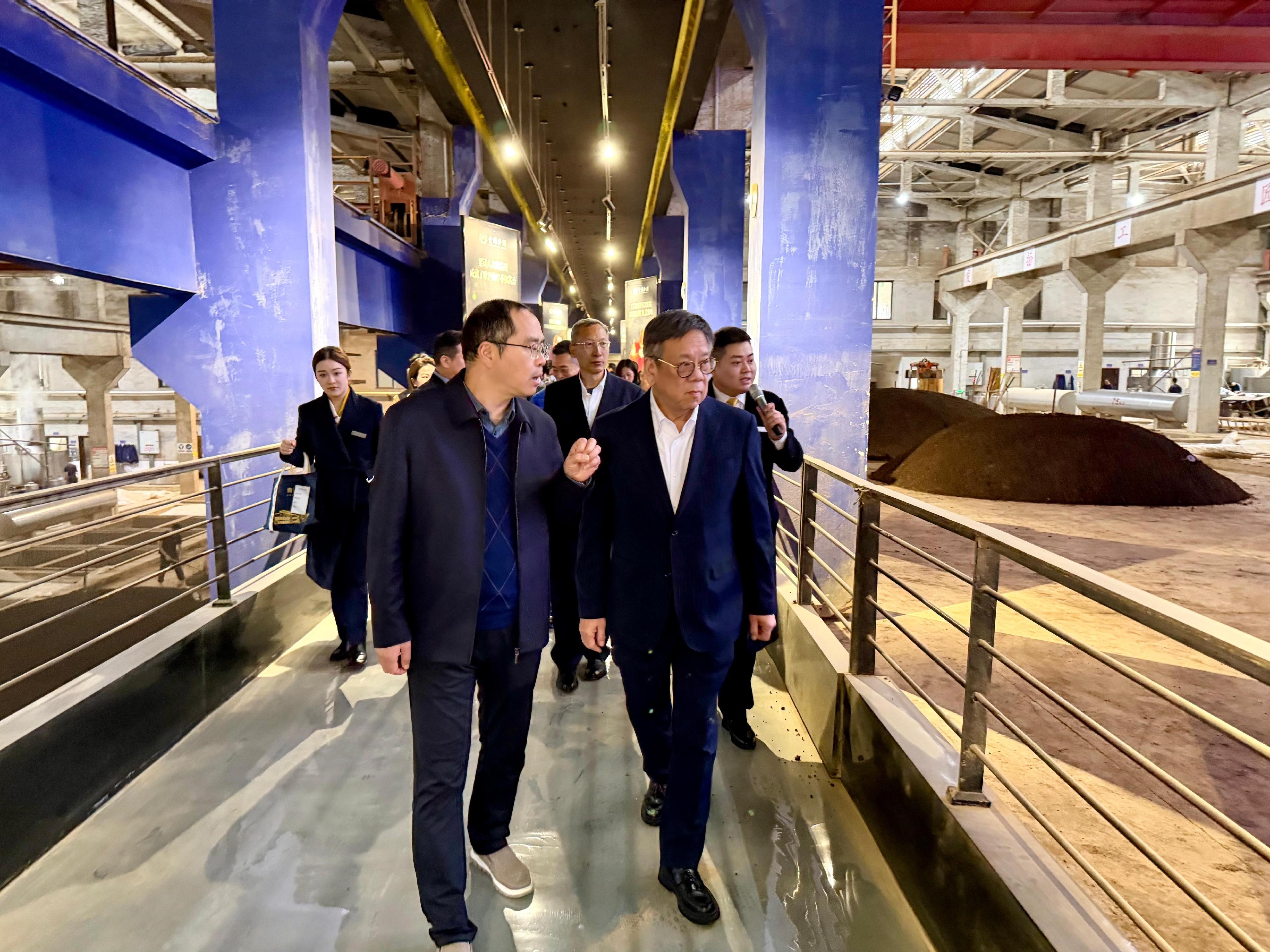The business delegation led by the Secretary for Commerce and Economic Development, Mr Algernon Yau, proceeded to Guizhou from Sichuan to continue its visit. Photo shows Mr Yau (right) visiting the distillery of Zhenjiu in Zunyi City, Guizhou, today (March 27) and being briefed by its representatives on the history and development of the brand.