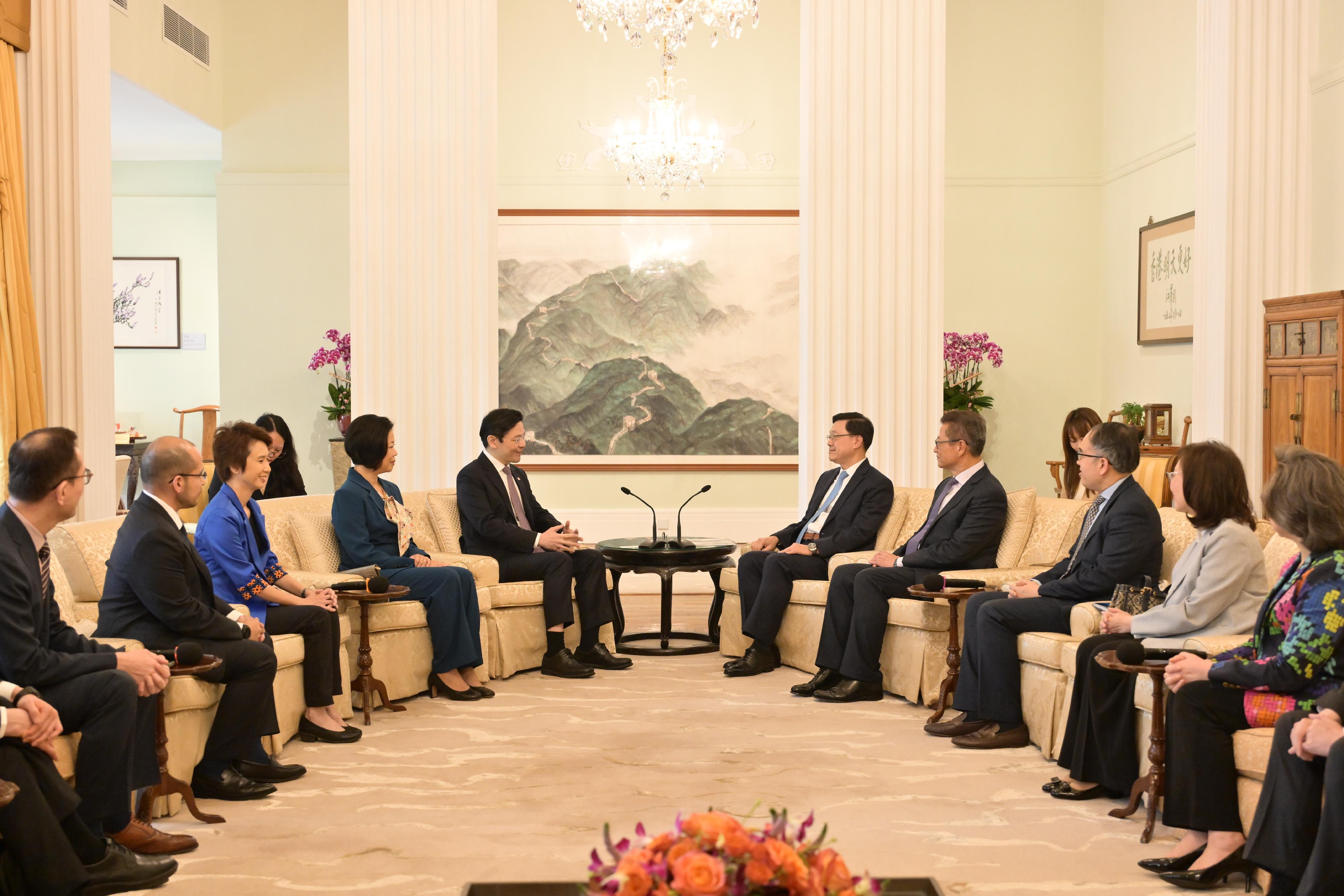The Chief Executive, Mr John Lee, met with the visiting Prime Minister and Minister for Finance of Singapore, Mr Lawrence Wong, at Government House today (March 27). Photo shows Mr Lee (fifth right) and Mr Wong (fifth left) exchanging views on issues of mutual concern at Government House.