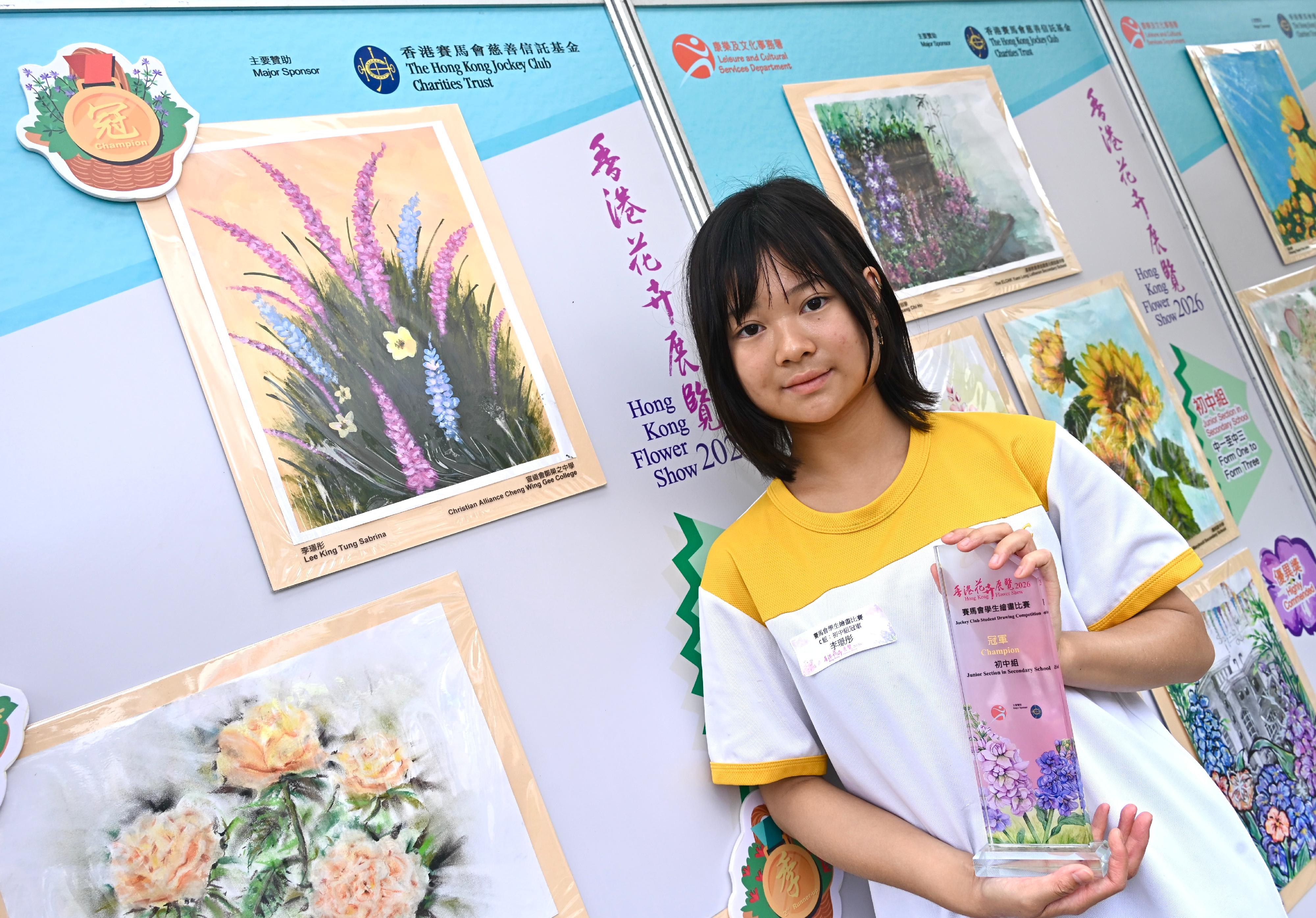 現於維多利亞公園舉行的香港花卉展覽明日（三月二十九日）晚上九時閉幕。大會在展覽期間安排了多項文娛活動，當中的賽馬會學童繪畫比賽今日（三月二十八日）舉行頒獎典禮，場內同時展出得獎作品。比賽分五個組別，圖示初中組冠軍李璟彤及其作品。
