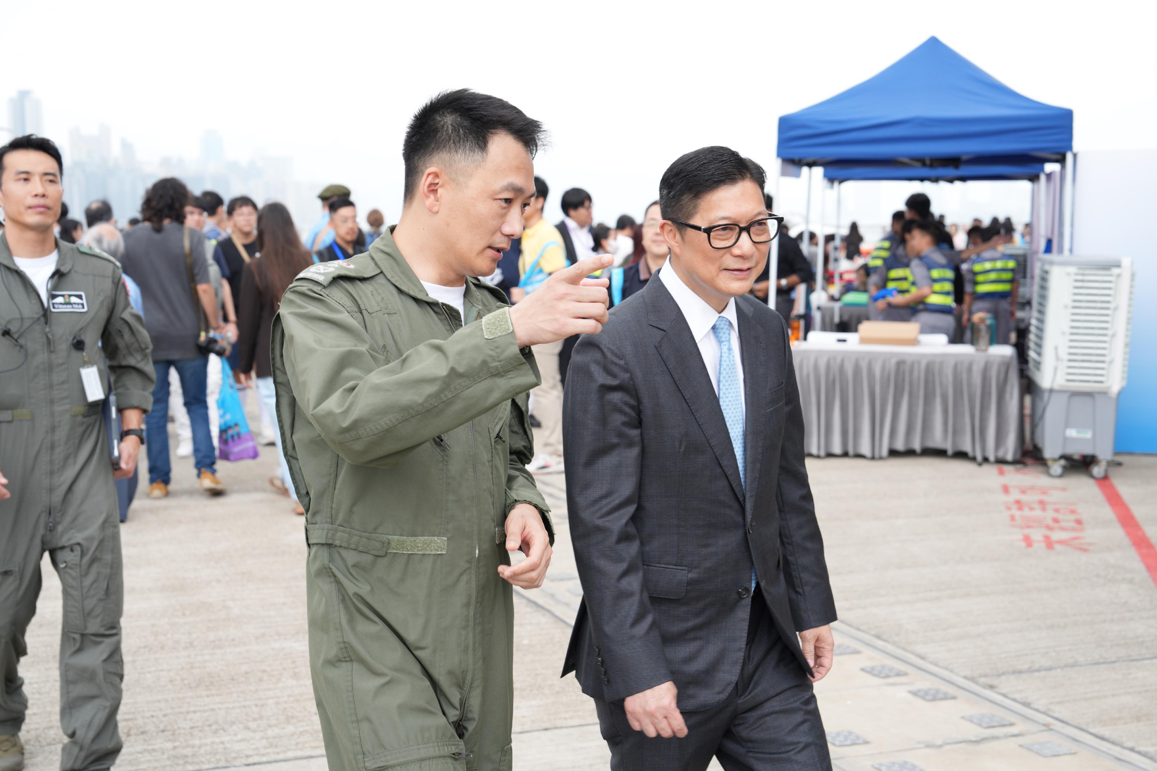 為全力推廣「全民國家安全教育日」,政府飛行服務隊今日(三月二十九日)在啟德分部舉辦開放日。圖示保安局局長鄧炳強(右)聽取政府飛行服務隊總監廖嘉俊(左)匯報開放日安排。