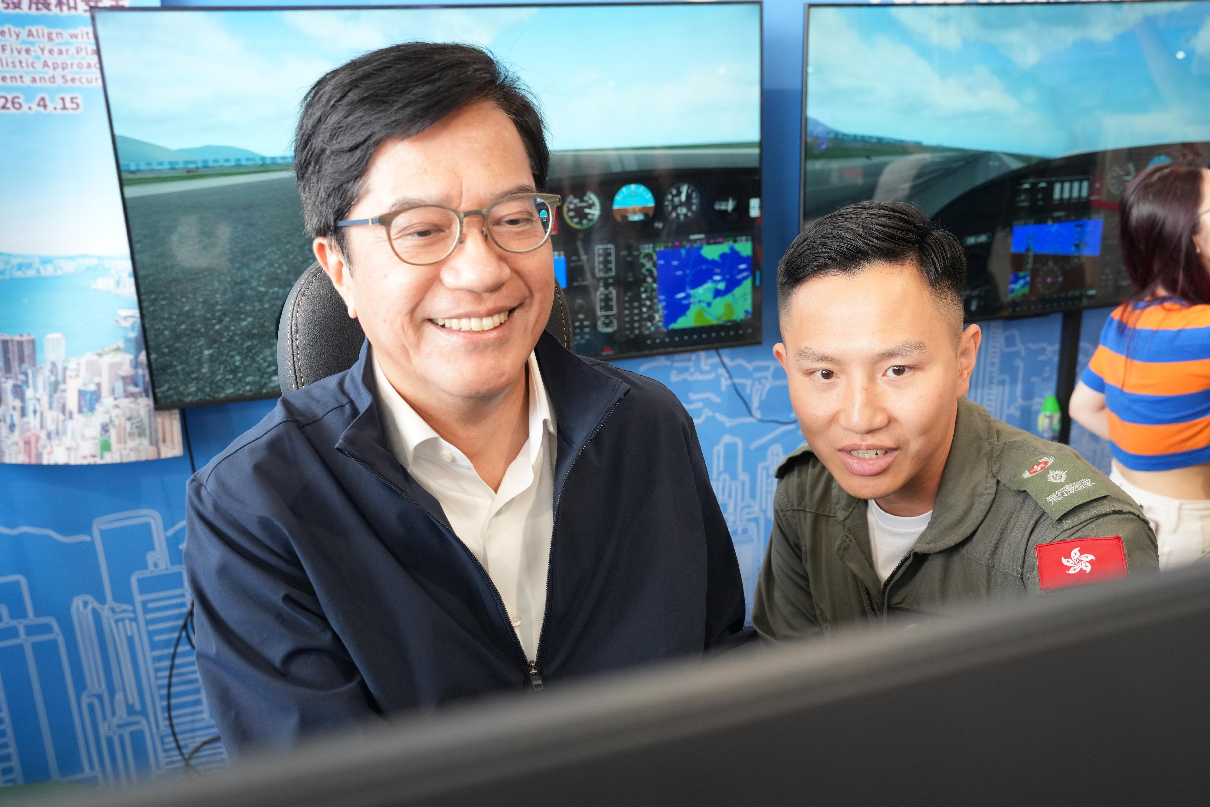 To promote the National Security Education Day, the Government Flying Service (GFS) held an open day today (March 29) at the GFS Kai Tak Division. Photo shows the Deputy Financial Secretary, Mr Michael Wong (left), having fixed-wing aircraft flight simulation experience.