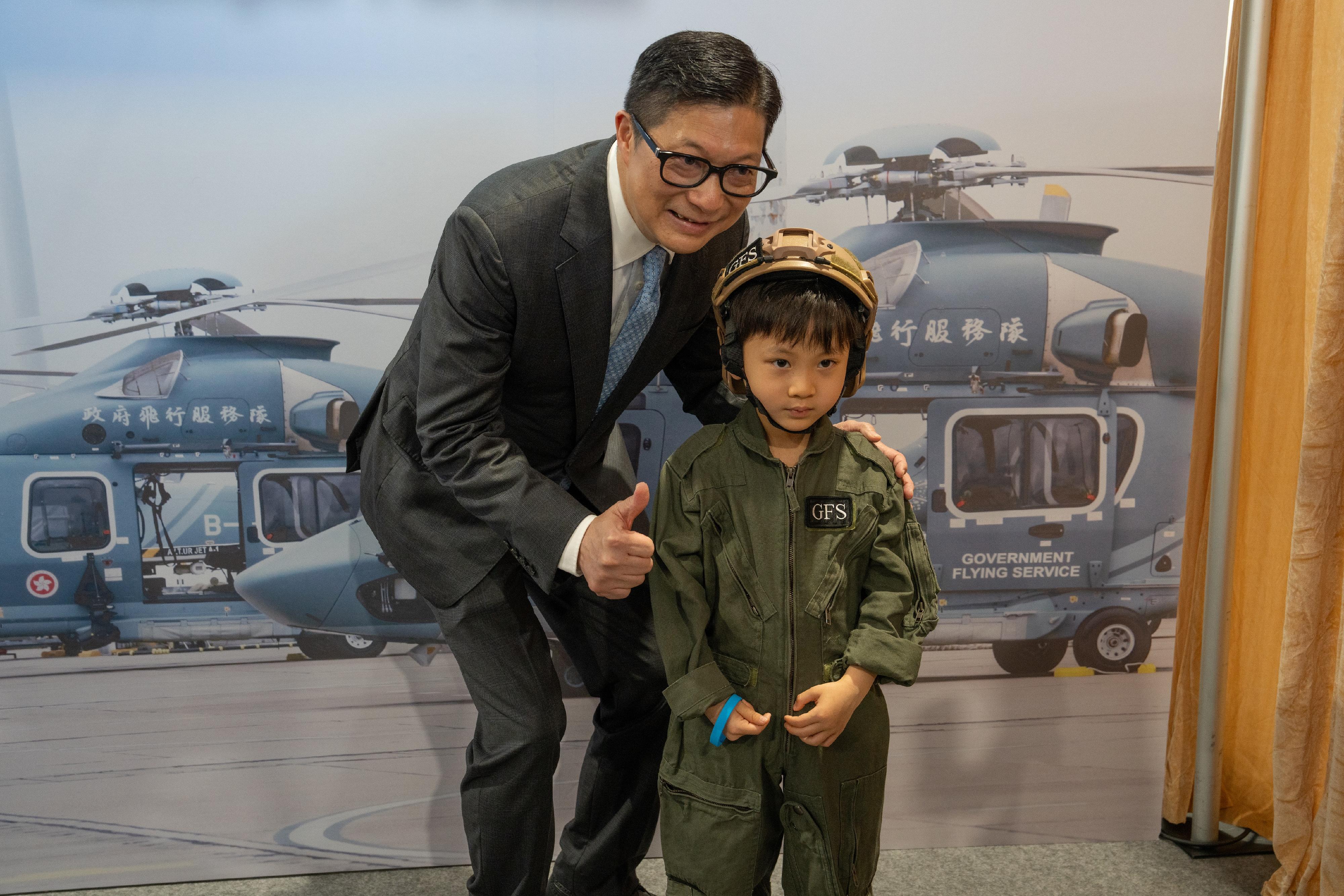 To promote the National Security Education Day, the Government Flying Service (GFS) held an open day today (March 29) at the GFS Kai Tak Division. Photo shows the Secretary for Security, Mr Tang Ping-keung (left), with a member of the public visiting the exhibition booth.